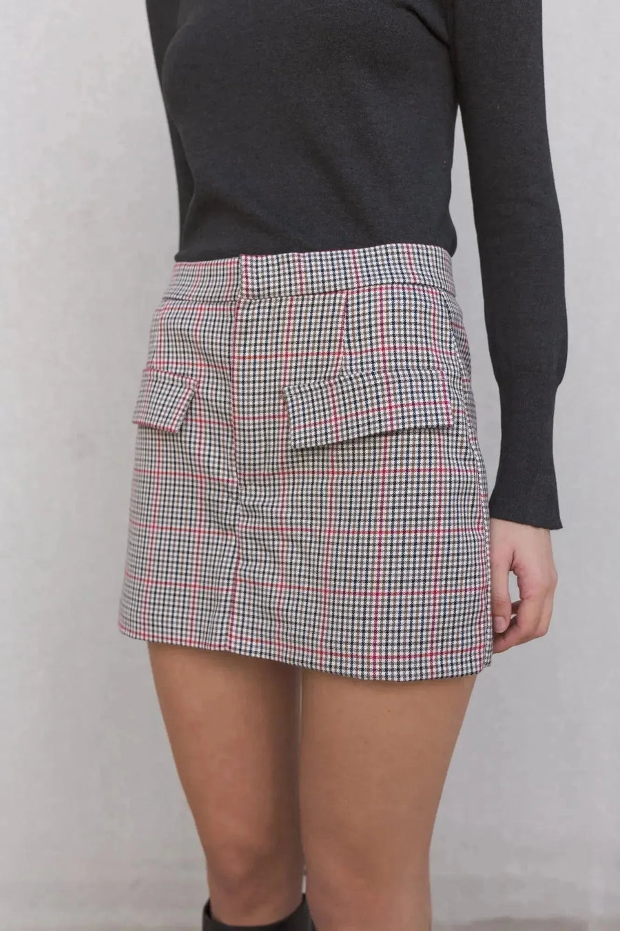 Zoom sur la jupe-short à carreaux femme taille haute, soulignant les poches et le motif stylé du skort.