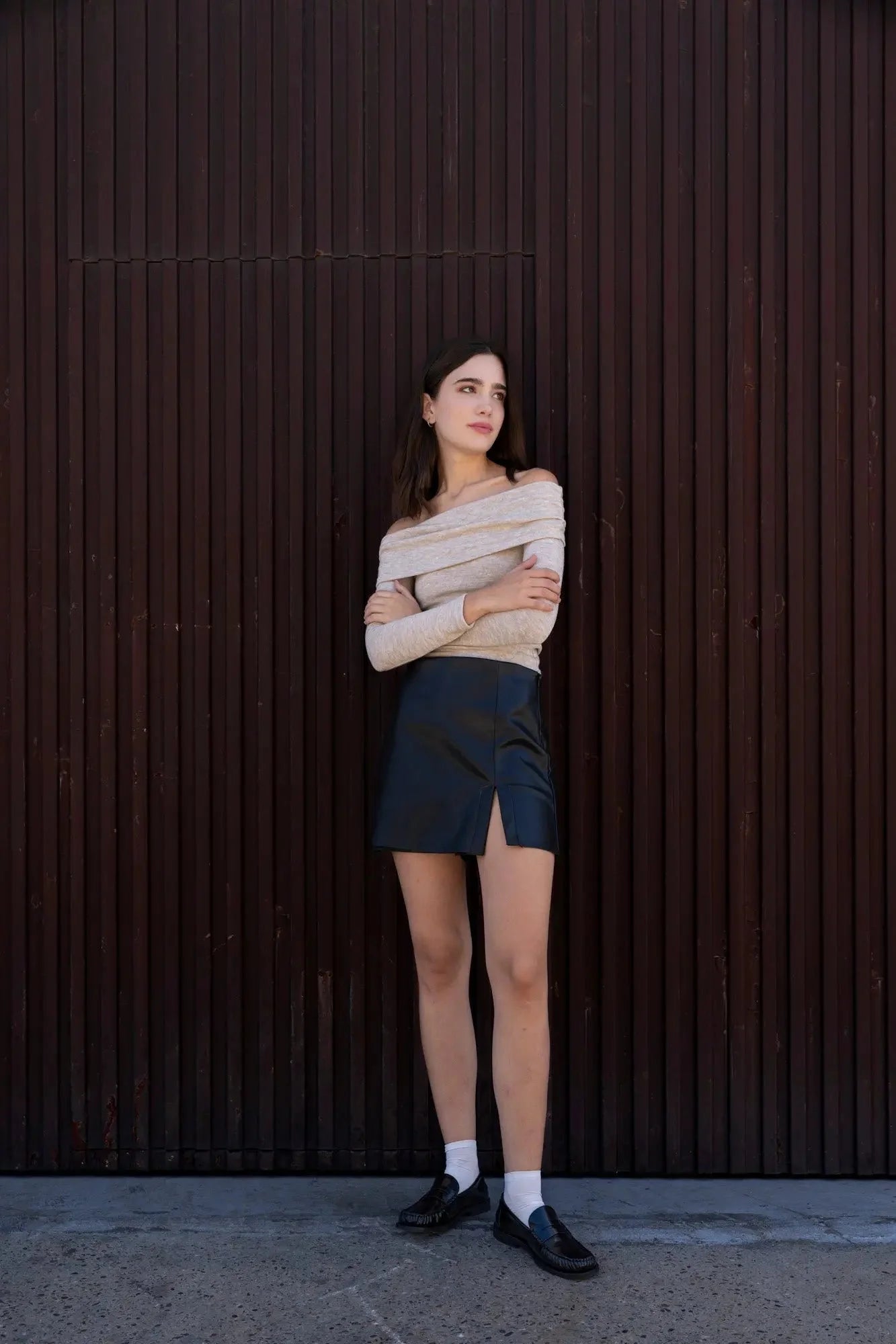 Femme portant une jupe short effet cuir et top épaules dénudées pour un look tendance