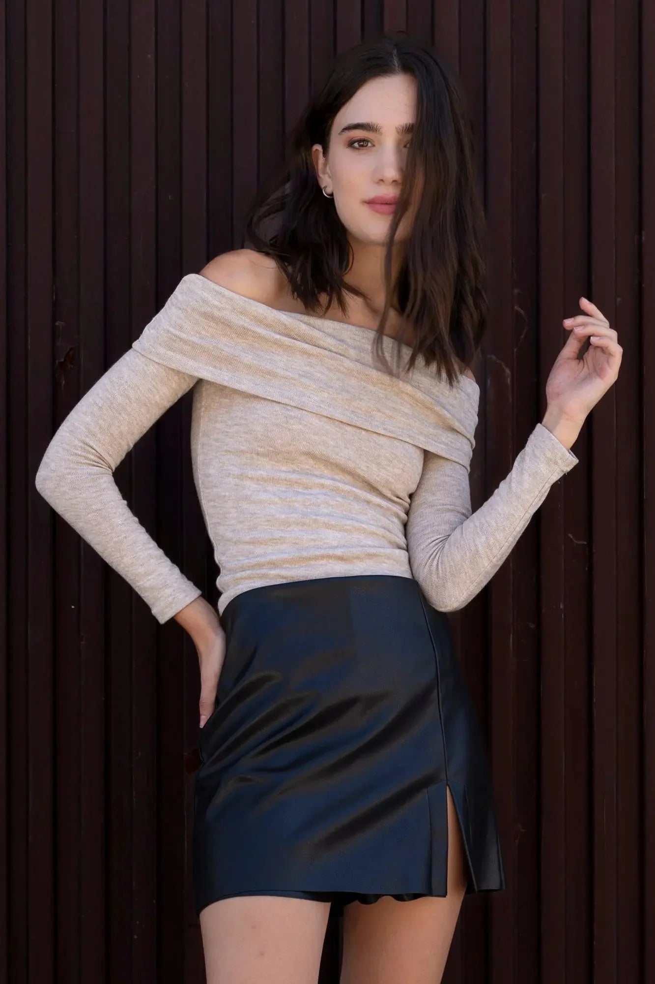 Femme portant une jupe short effet cuir et un haut beige à manches longues