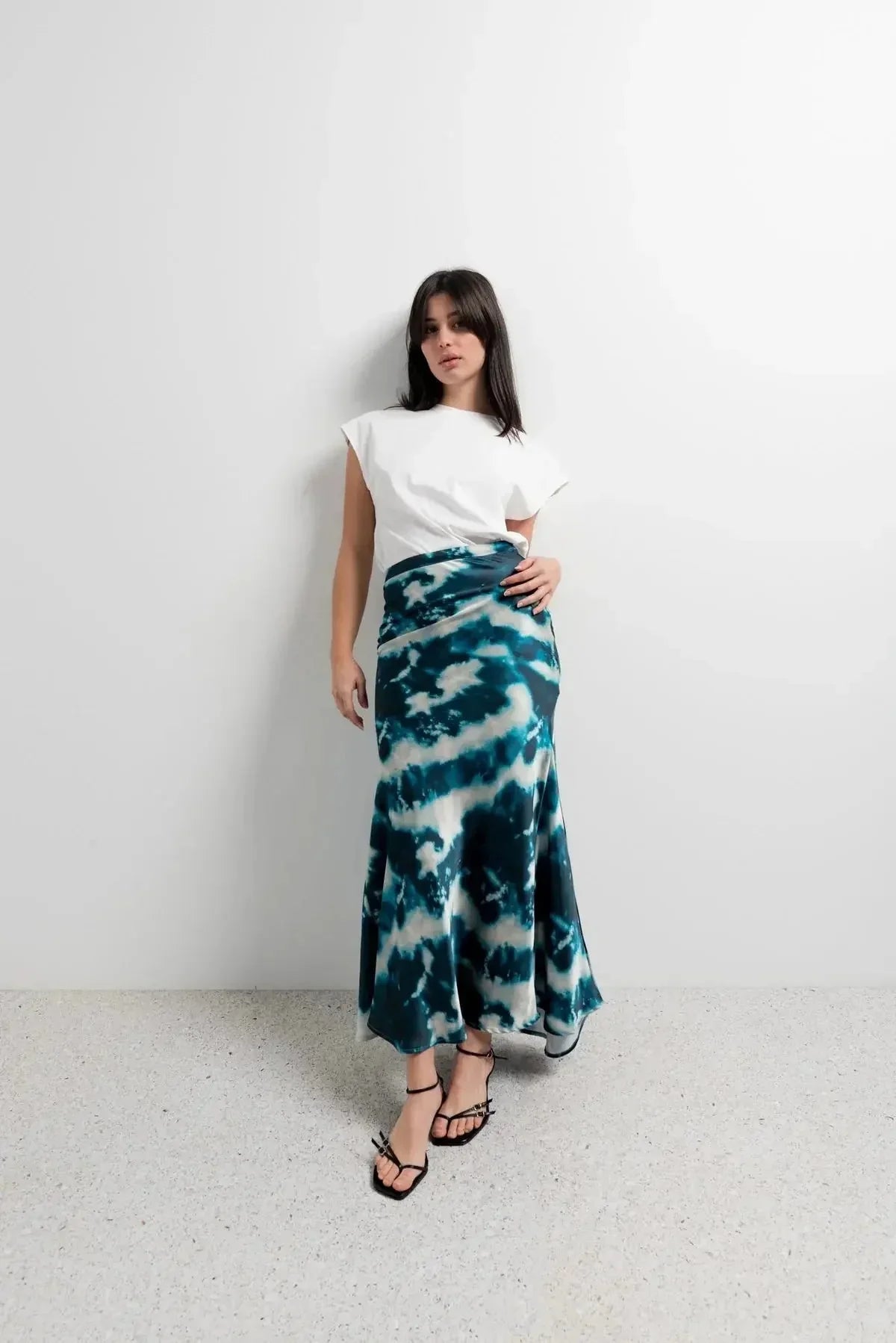 Look élégant avec une jupe tie and dye satinée et un t-shirt simple, idéal pour un style décontracté et artistique.