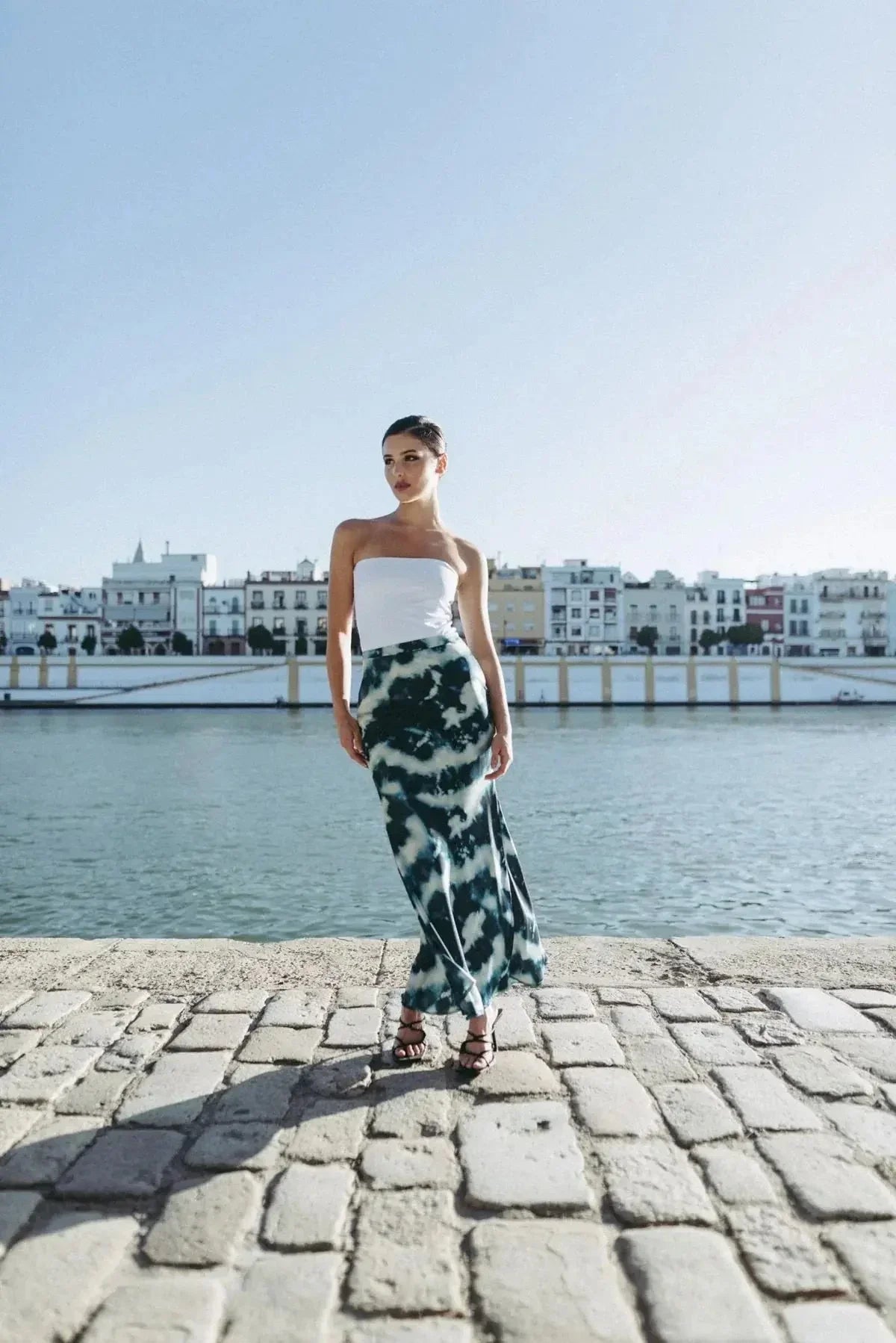 Modèle portant la Jupe Tie and Dye Satinée Élégante au bord de l'eau, illustrant style et confort pour toutes les occasions.