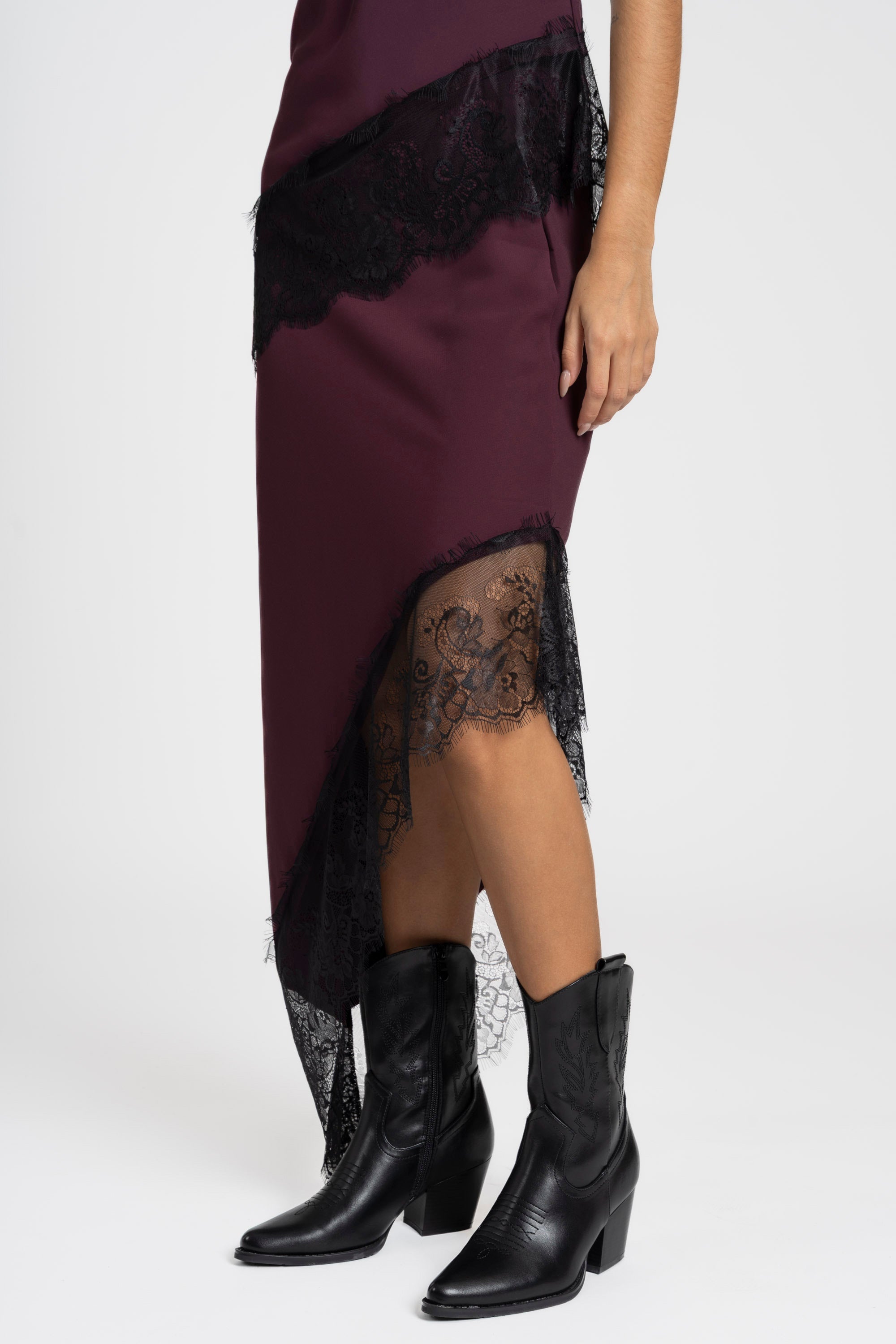 Zoom sur la partie inférieure de la jupe dentelle asymétrique violet, soulignant la texture et le mouvement de la dentelle.