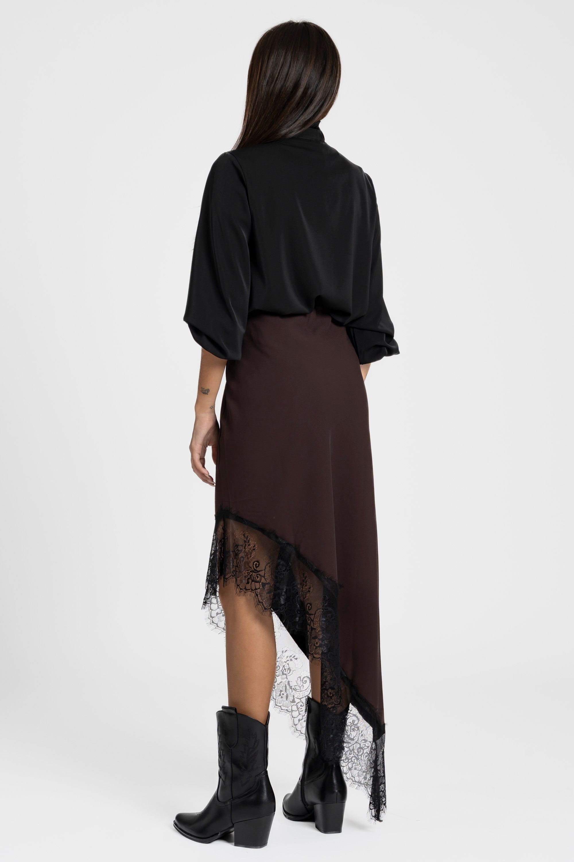 Vue arrière de la jupe dentelle asymétrique marron, illustrant le beau tombé de la dentelle.