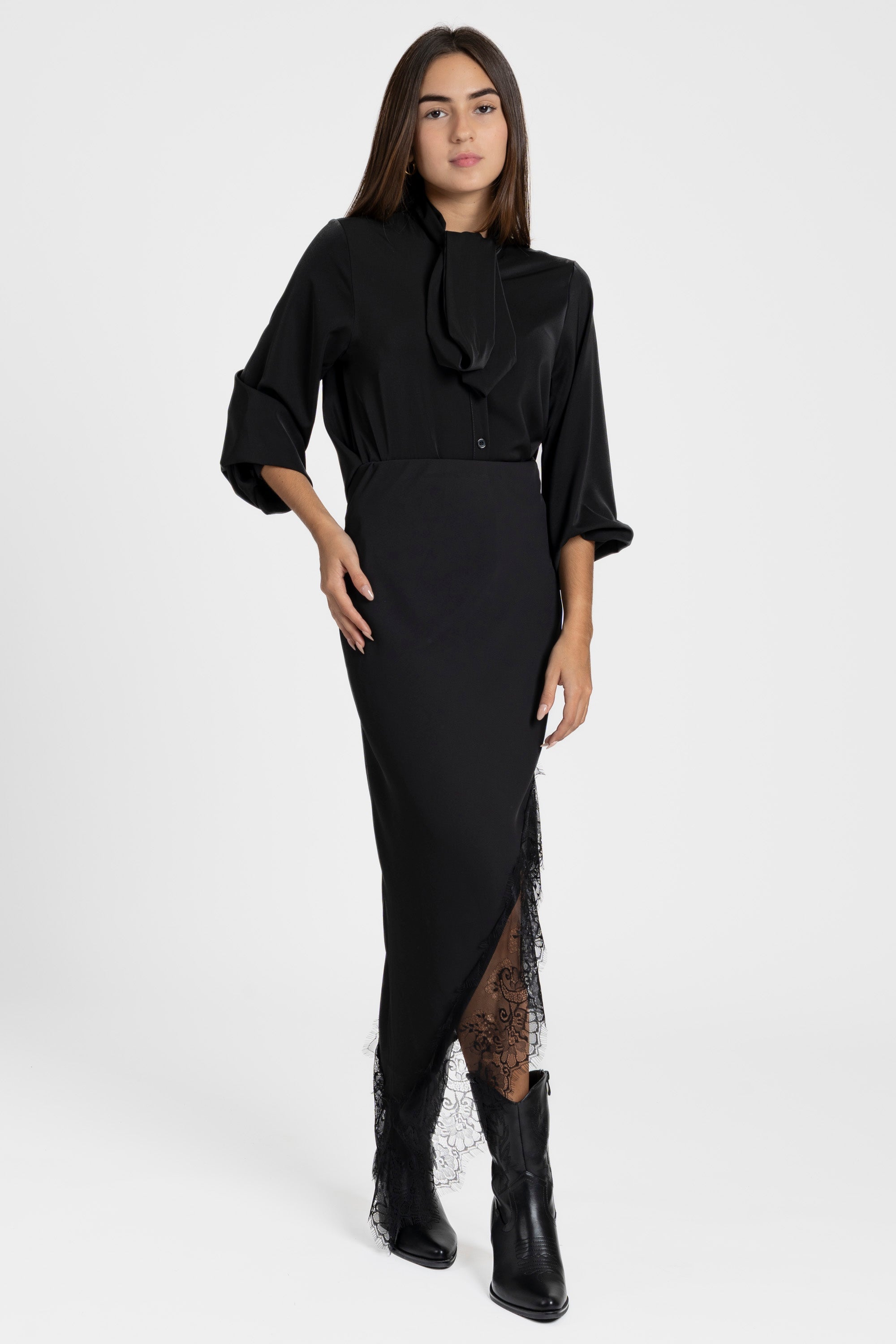 Modèle féminin en jupe dentelle asymétrique noire, style élégant et sophistiqué, prêt pour une soirée.