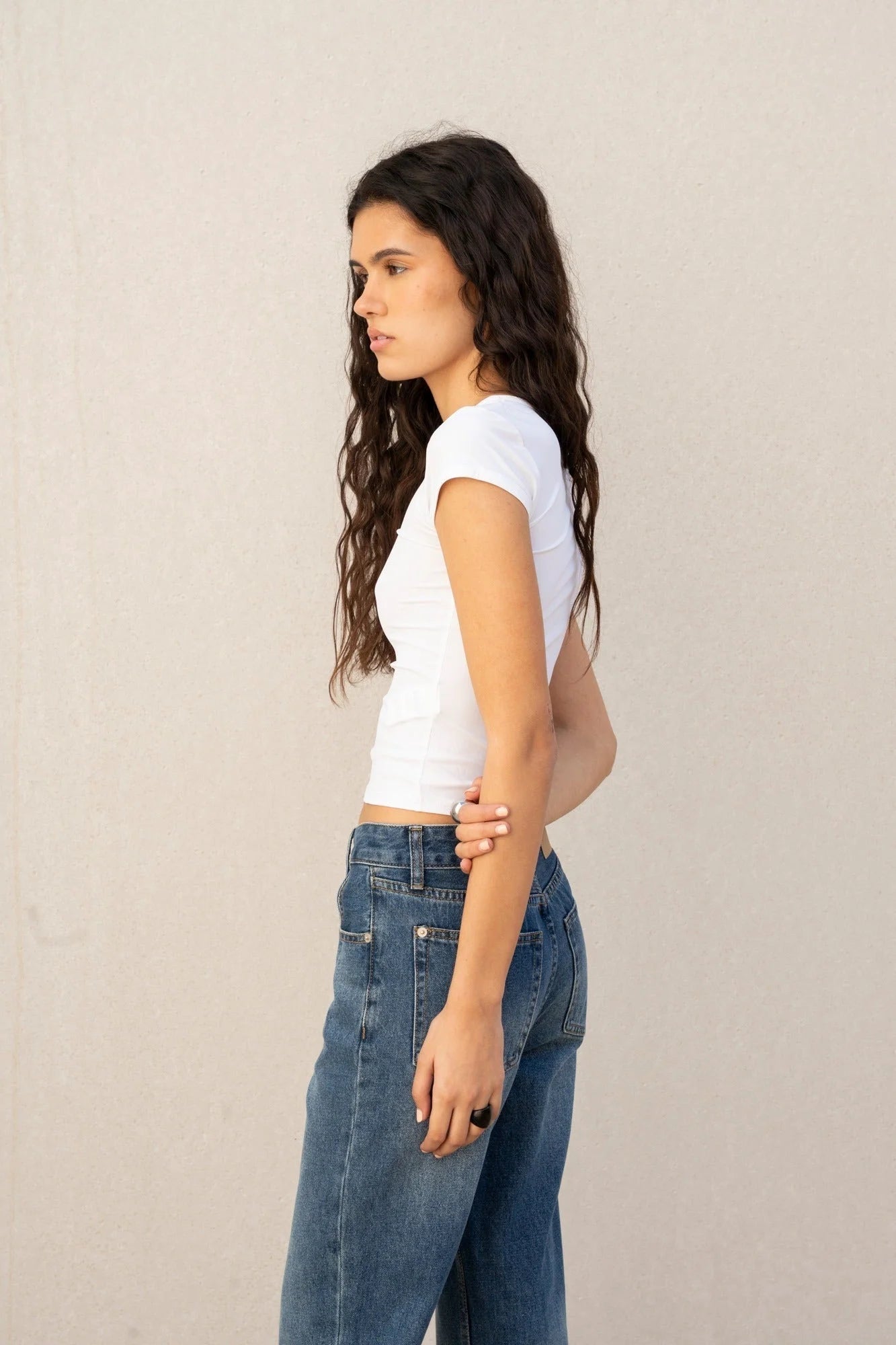 Femme portant un T-shirt blanc aux jeans décontractés pour un look casual élégant