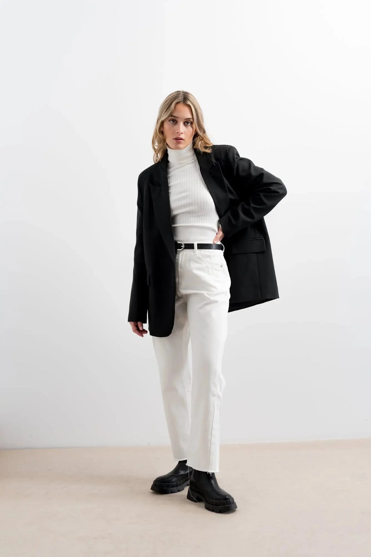 Modèle stylé avec un pull col roulé femme, portant des vêtements chic et décontractés, représentant les indispensables de la garde-robe d’hiver.