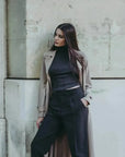 Modèle en pull col roulé femme noir, accompagné d'un trench, illustrant les indispensables de la garde-robe d’hiver.