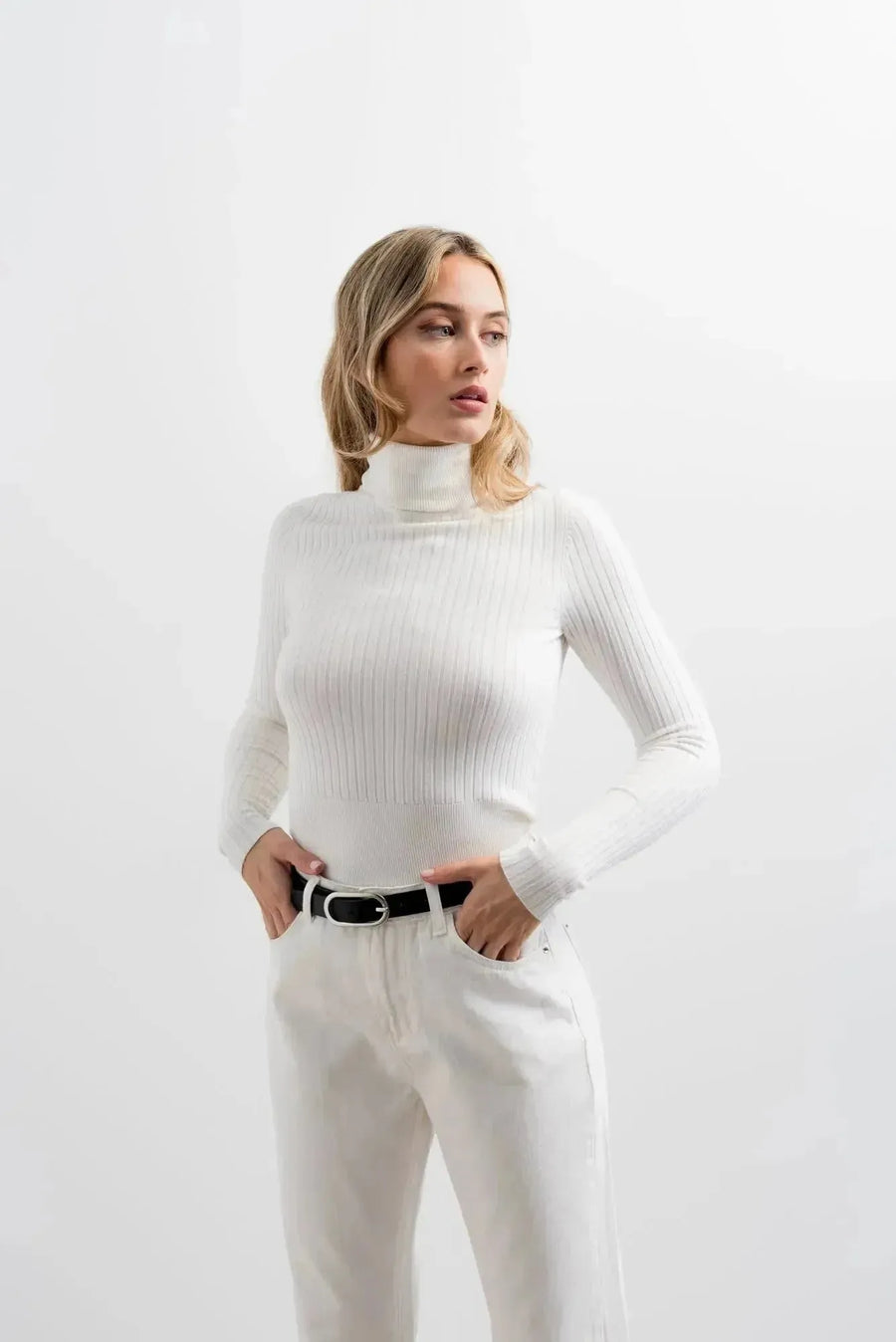 Look décontracté avec un pull col roulé femme en blanc, une pièce essentielle pour l'hiver, faisant partie des indispensables de la garde-robe d’hiver.