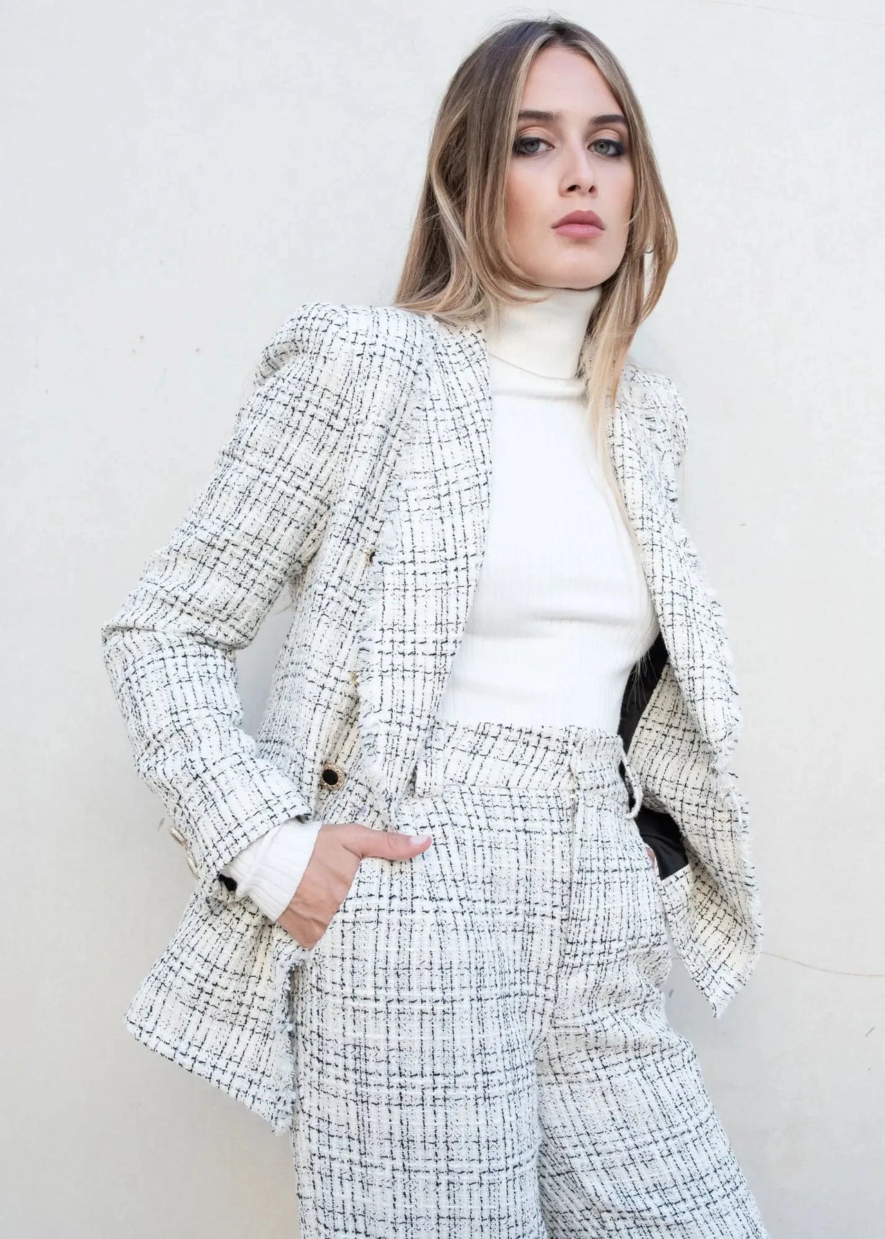 Femme portant un blazer et un pull col roulé femme, parfait pour l'hiver, accessible dans les indispensables de la garde-robe d’hiver.