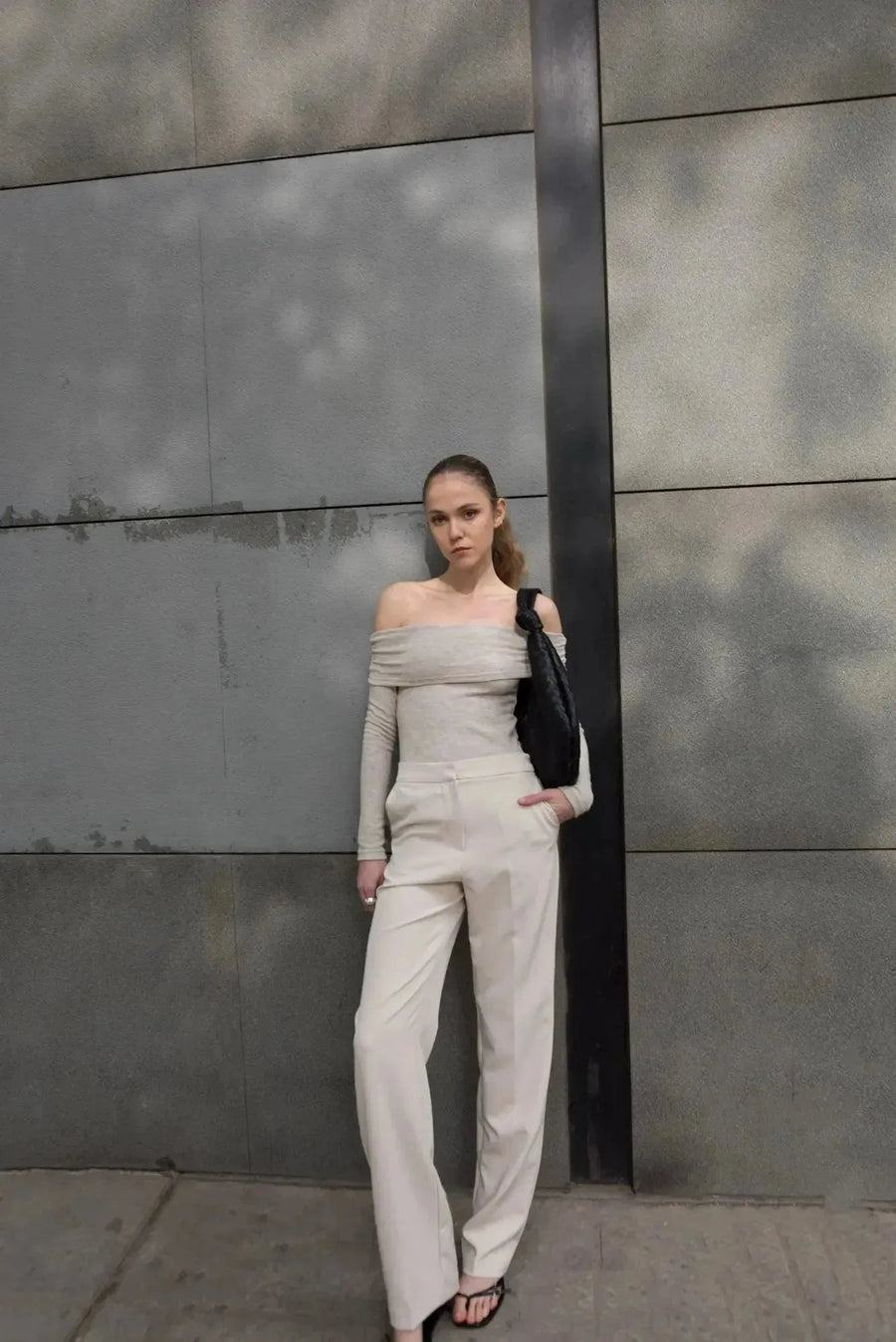 Modèle en pantalon droit femme beige avec un haut blanc, capturant une pose élégante et contemporaine.