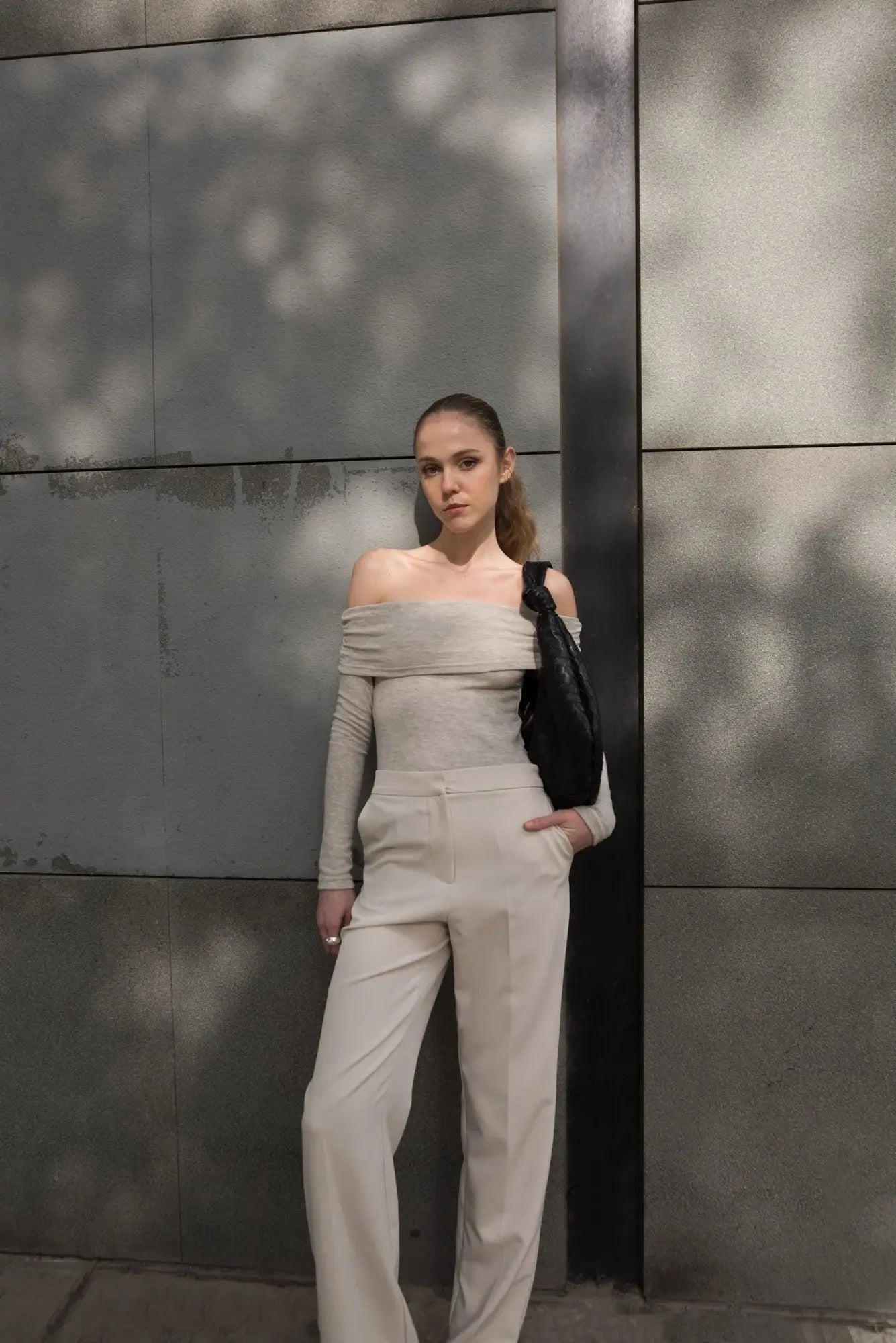 Femme portant un look beige pour une élégance intemporelle avec sac noir