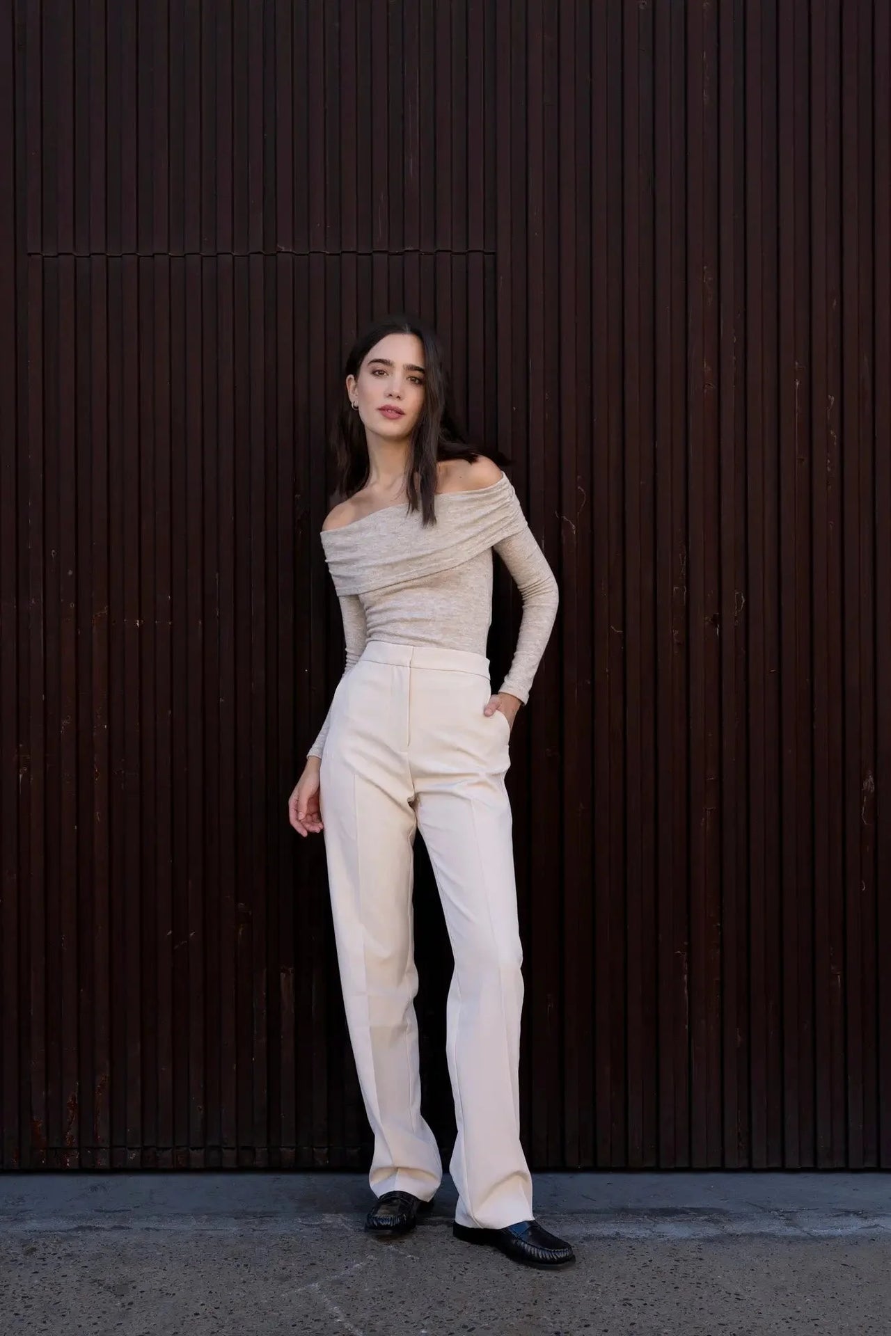 Femme en pantalon droit femme beige, élégamment posée avec un look chic et moderne, mettant en avant le confort et le style.