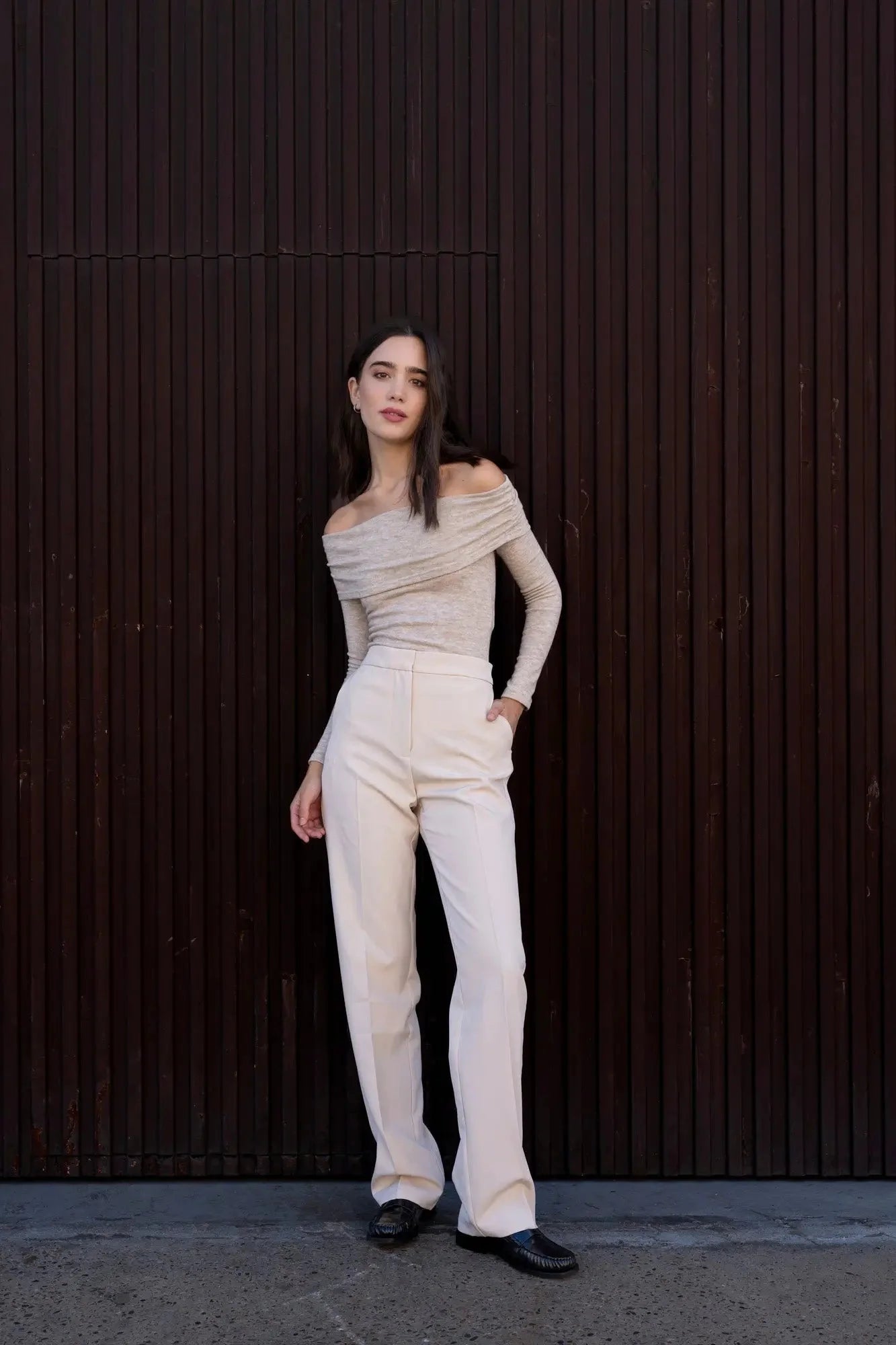 Femme portant un haut beige et pantalon large pour une élégance intemporelle