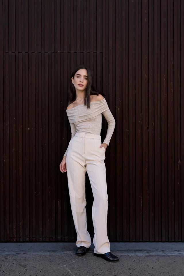 Femme en pantalon droit femme beige, élégamment posée avec un look chic et moderne, mettant en avant le confort et le style.