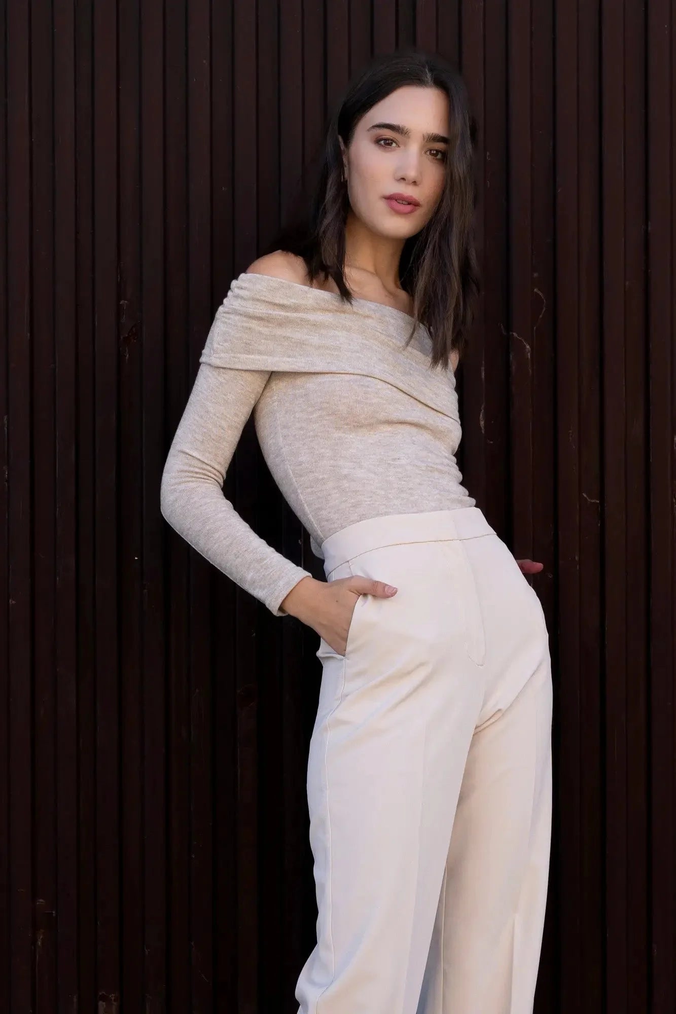 Femme portant un haut beige décolleté et pantalon clair pour une élégance intemporelle