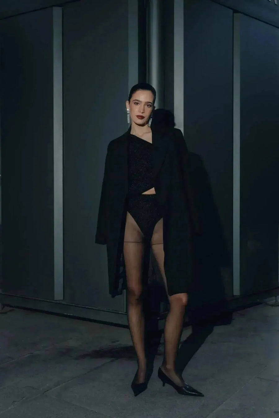 Manteau ajusté en laine pour femme, affichant une allure élégante dans un cadre nocturne. Manteau femme chic hiver.