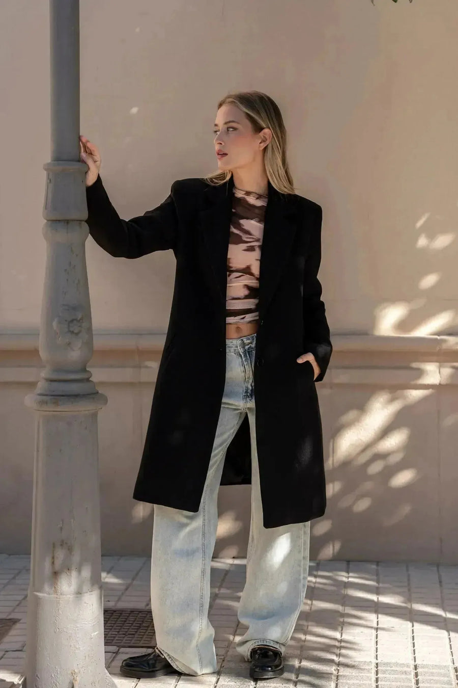 Manteau ajusté en laine pour femme, porté avec un ensemble casual, parfait pour un look décontracté en hiver. Manteau femme chic hiver.