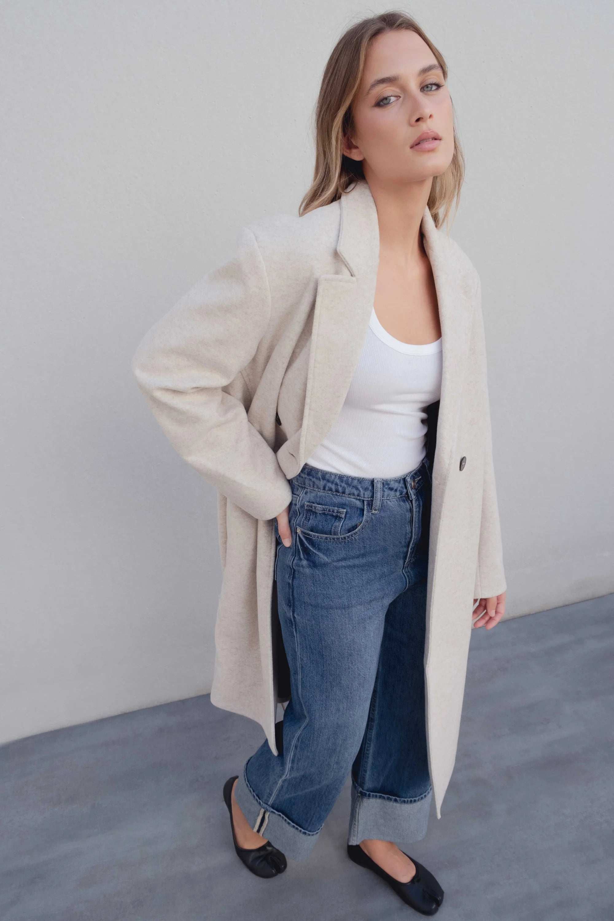 Femme portant un manteau croisé beige clair avec design croisé et style élégant