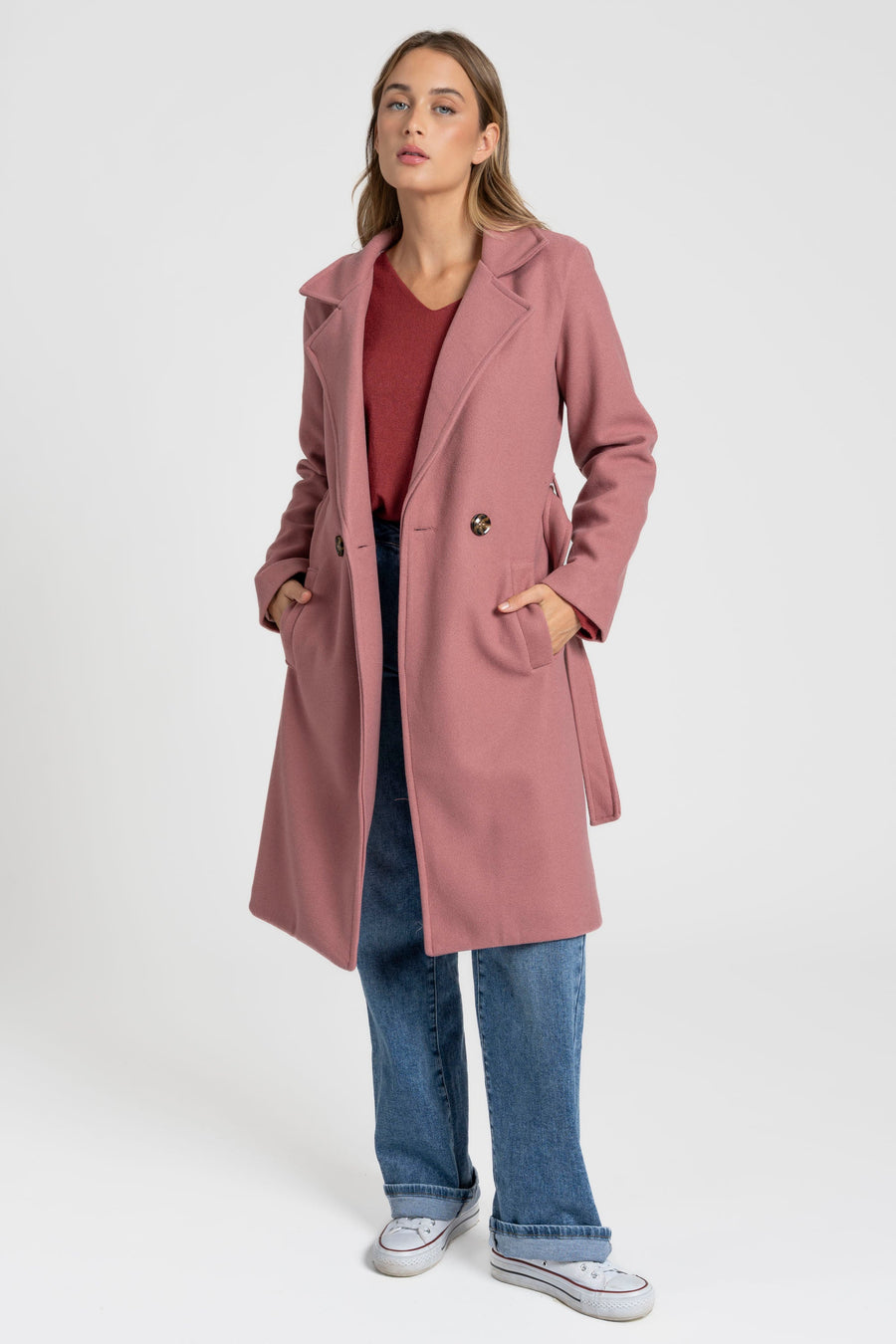 Manteau rose ouvert avec les mains dans les poches, vue en pied