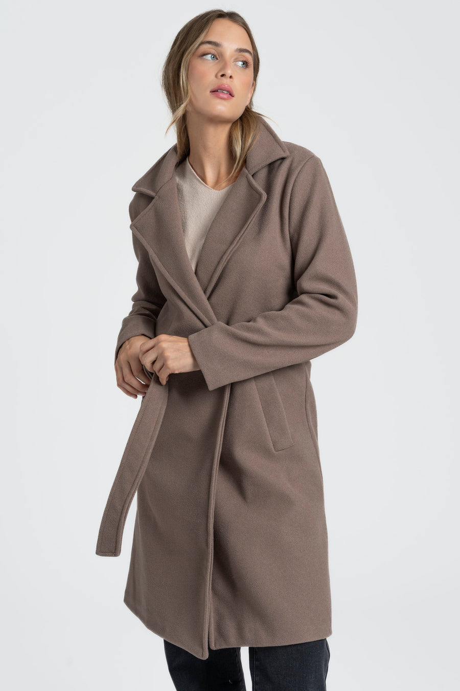 Manteau taupe vu de trois quarts, ceinture tenue devant la taille