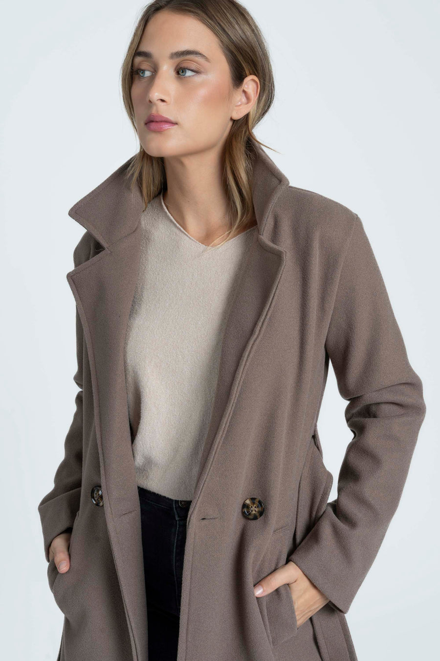 Détail des revers, des boutons et des poches du manteau taupe ouvert