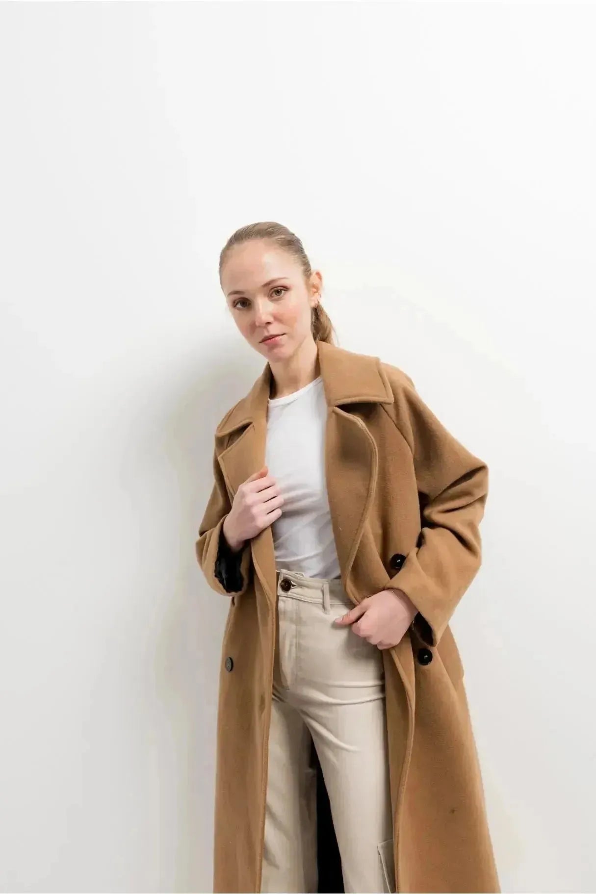 Femme en manteau long en laine double boutonnage camel avec un look stylé, idéal pour les jours froids, le manteau femme hiver long.