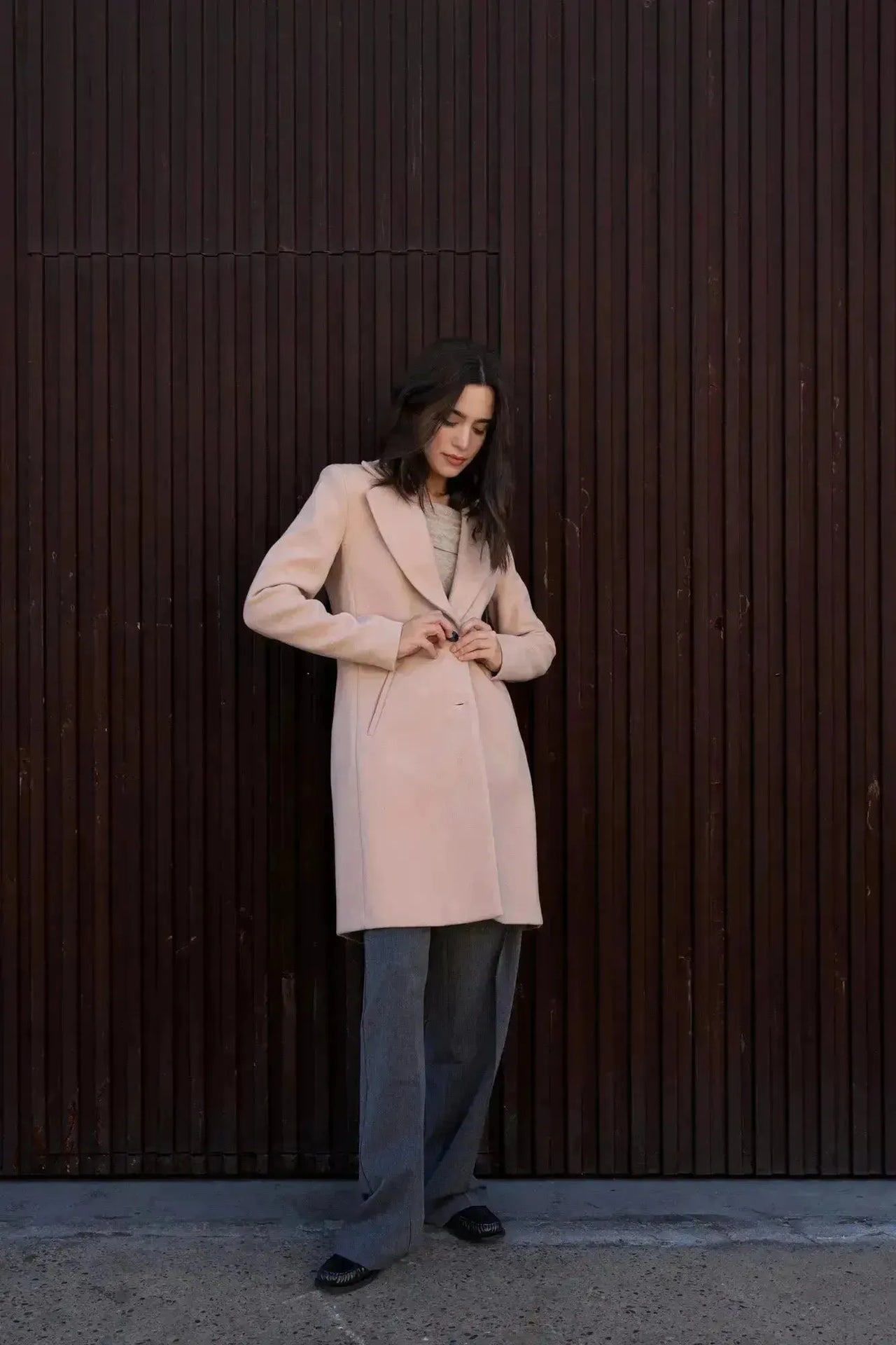 Modèle ajustant le manteau beige femme long élégant, idéal pour un look chic et confortable en hiver.