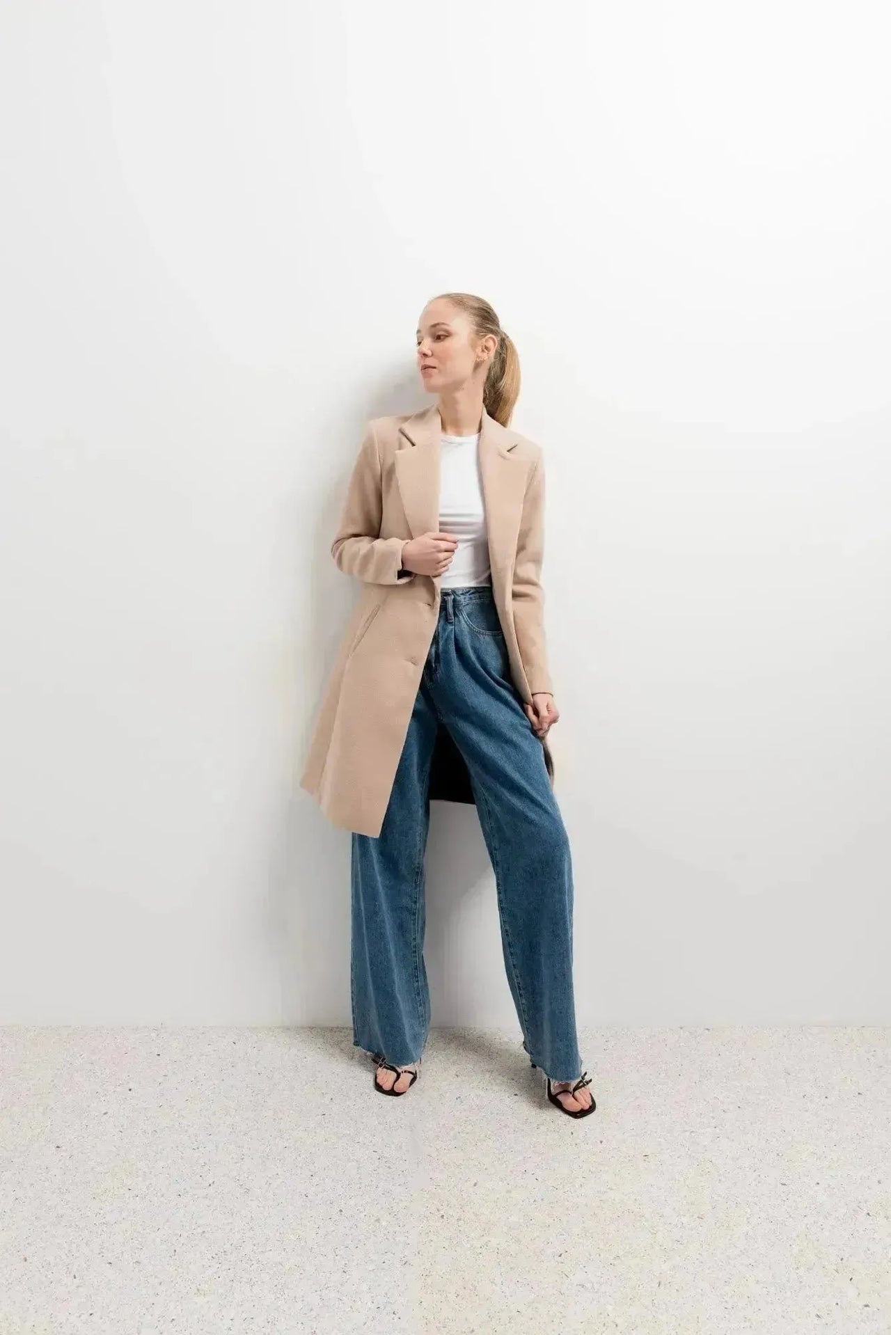 Modèle portant le manteau beige femme long élégant avec un look contemporain, parfait pour les sorties d'hiver.