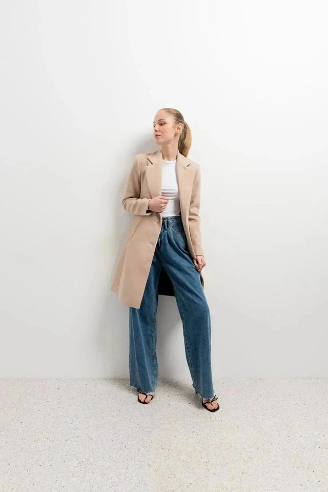 Modèle portant le manteau beige femme long élégant avec un look contemporain, parfait pour les sorties d'hiver.