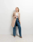 Modèle portant le manteau beige femme long élégant avec un look contemporain, parfait pour les sorties d'hiver.