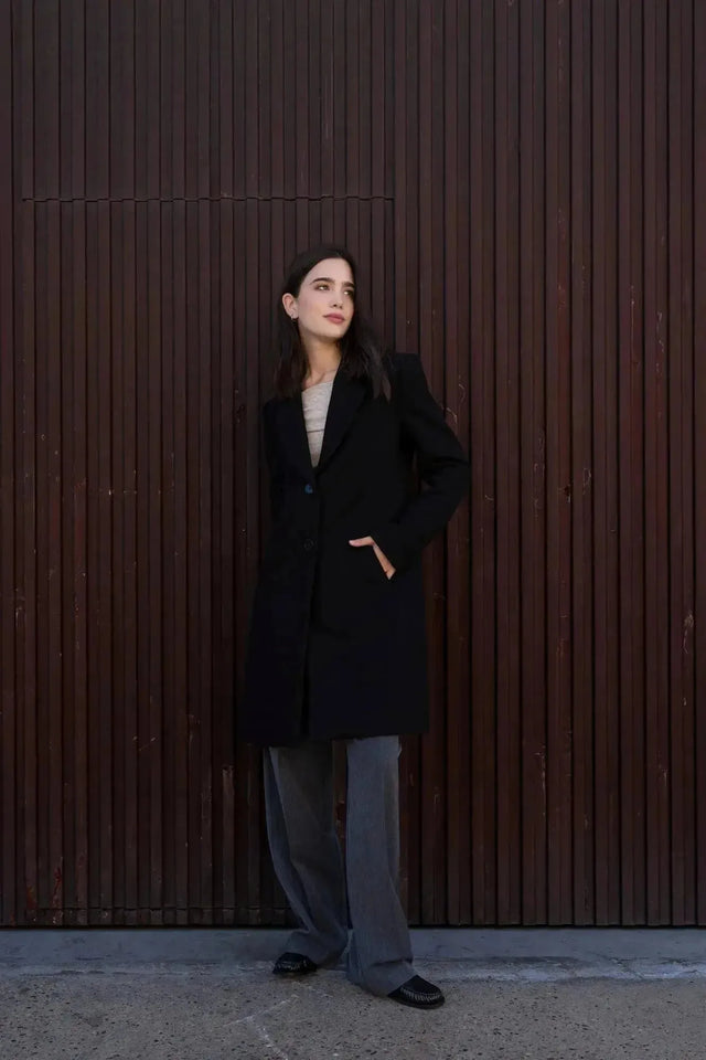 Manteau Long Chaud Femme: Femme posant avec un manteau noir chic et élégant, idéal pour rester au chaud et stylé pendant l'hiver.