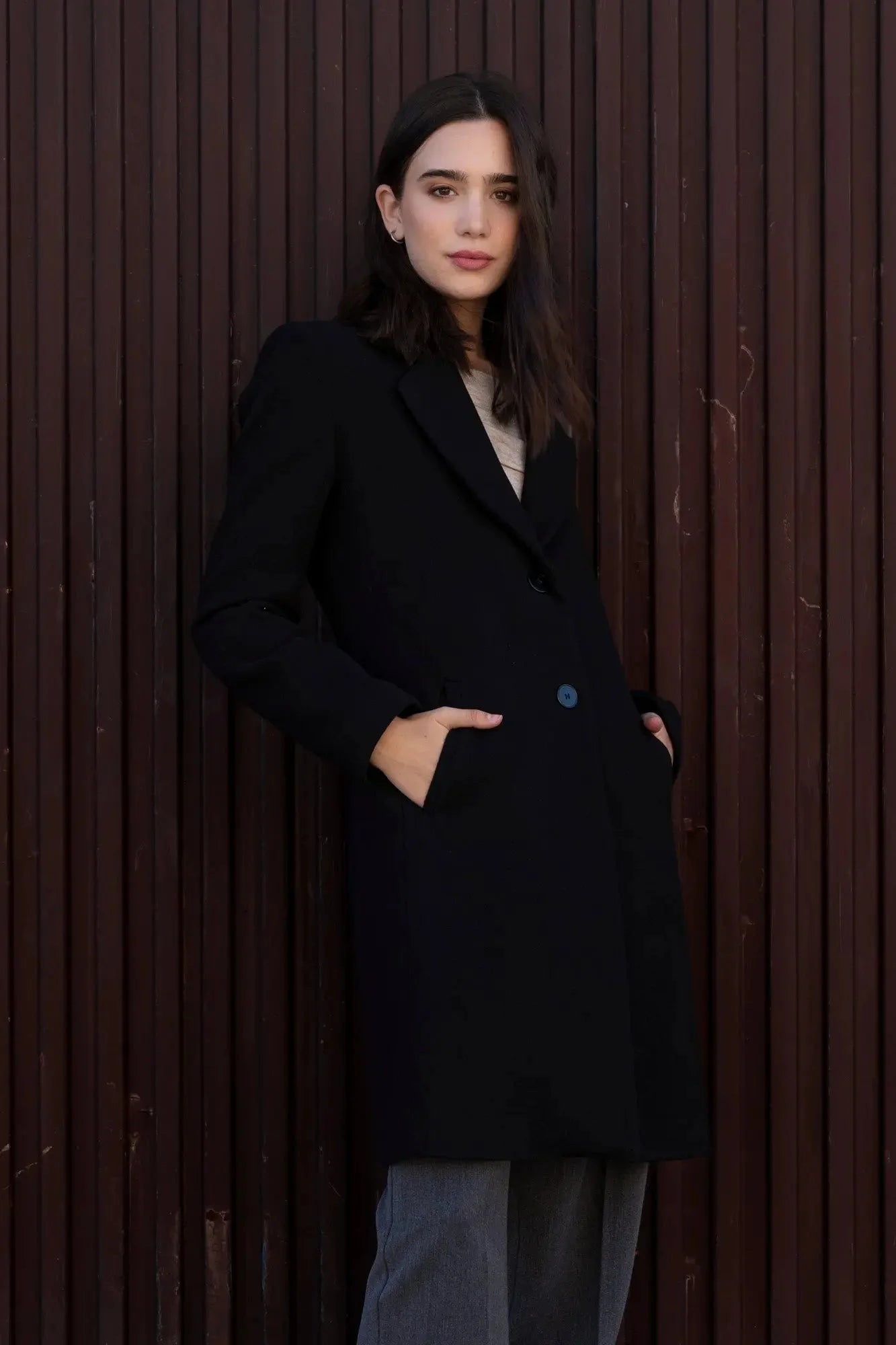 Femme portant un Manteau avec collier de revers noir et pantalon gris élégants
