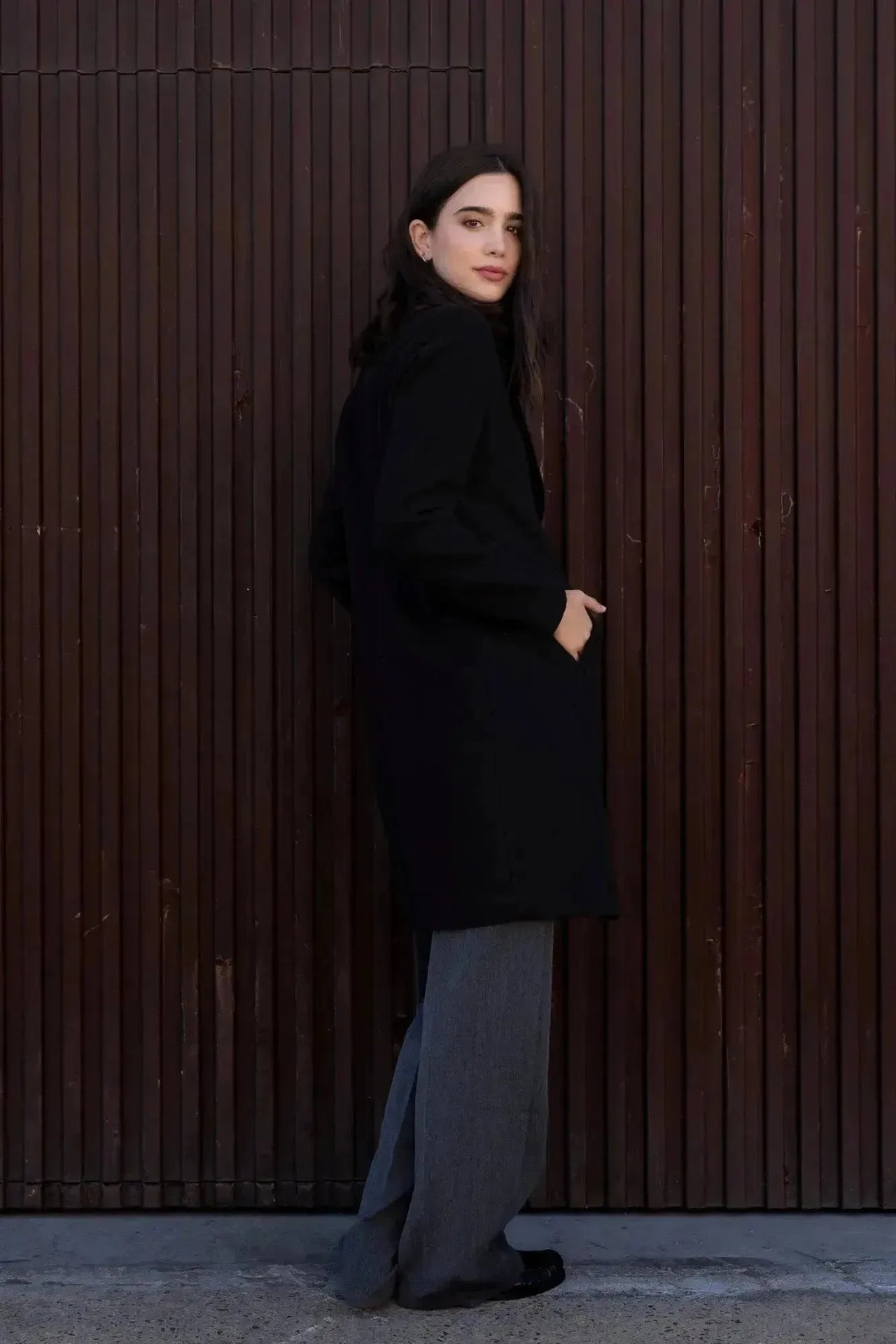 Manteau Long Chaud Femme: Femme souriante en manteau long noir, avec une touche de sophistication pour un look d'hiver tendance.
