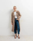 Femme en trench coat femme marron clair sur un look décontracté avec un haut blanc et un jean, pour un style quotidien.