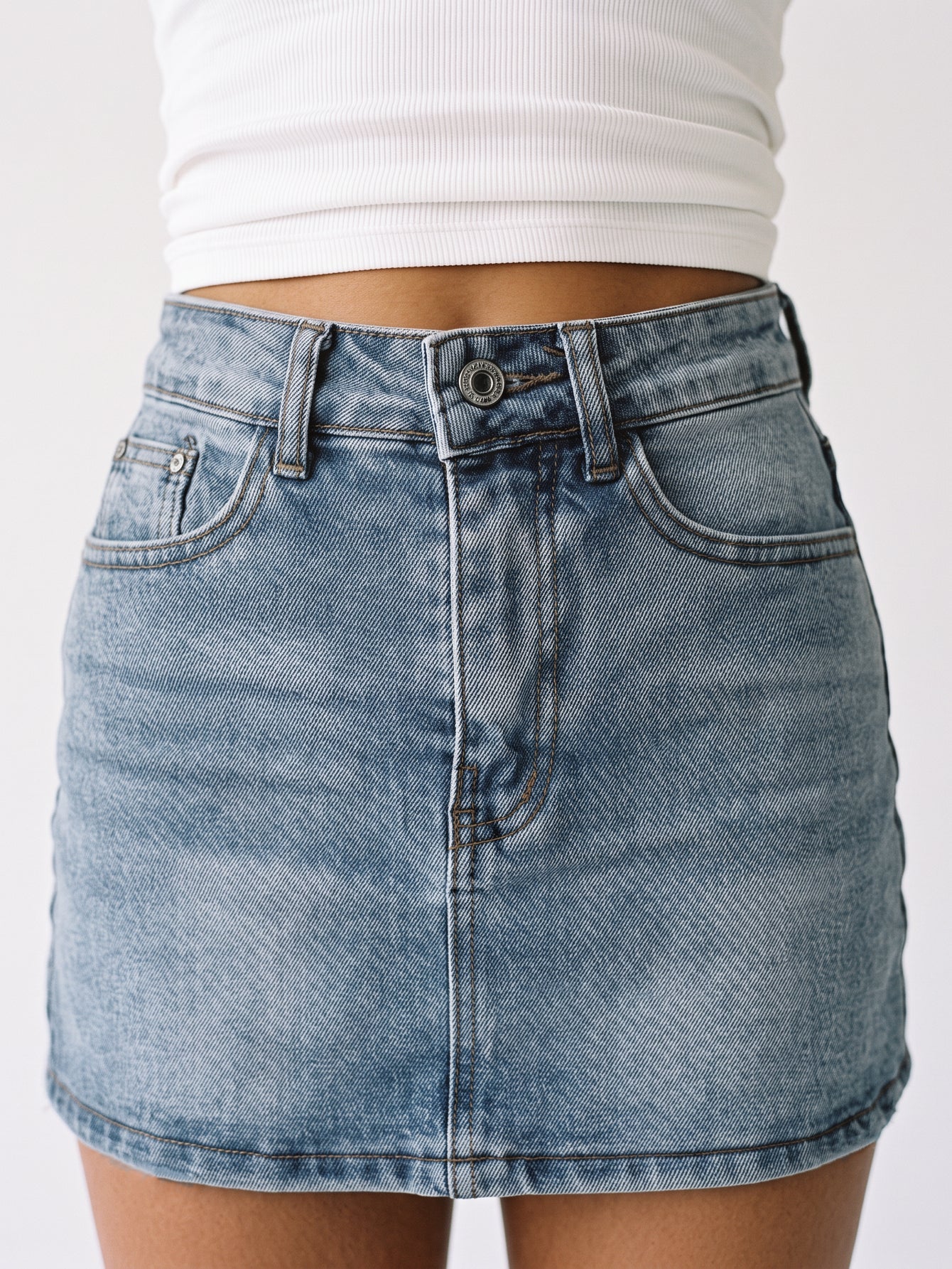 Mini jupe en denim gros plan taille bouton et zip