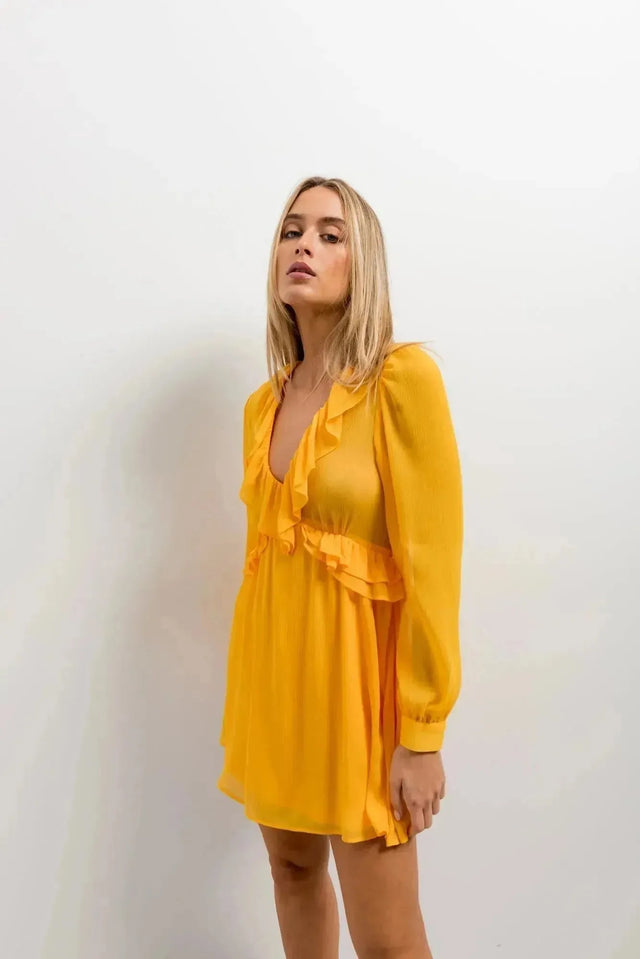 Détail d'un modèle en Mini Robe Courte Jaune à Volants, soulignant le style raffiné et moderne de cette robe courte jaune.