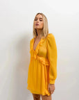 Détail d'un modèle en Mini Robe Courte Jaune à Volants, soulignant le style raffiné et moderne de cette robe courte jaune.