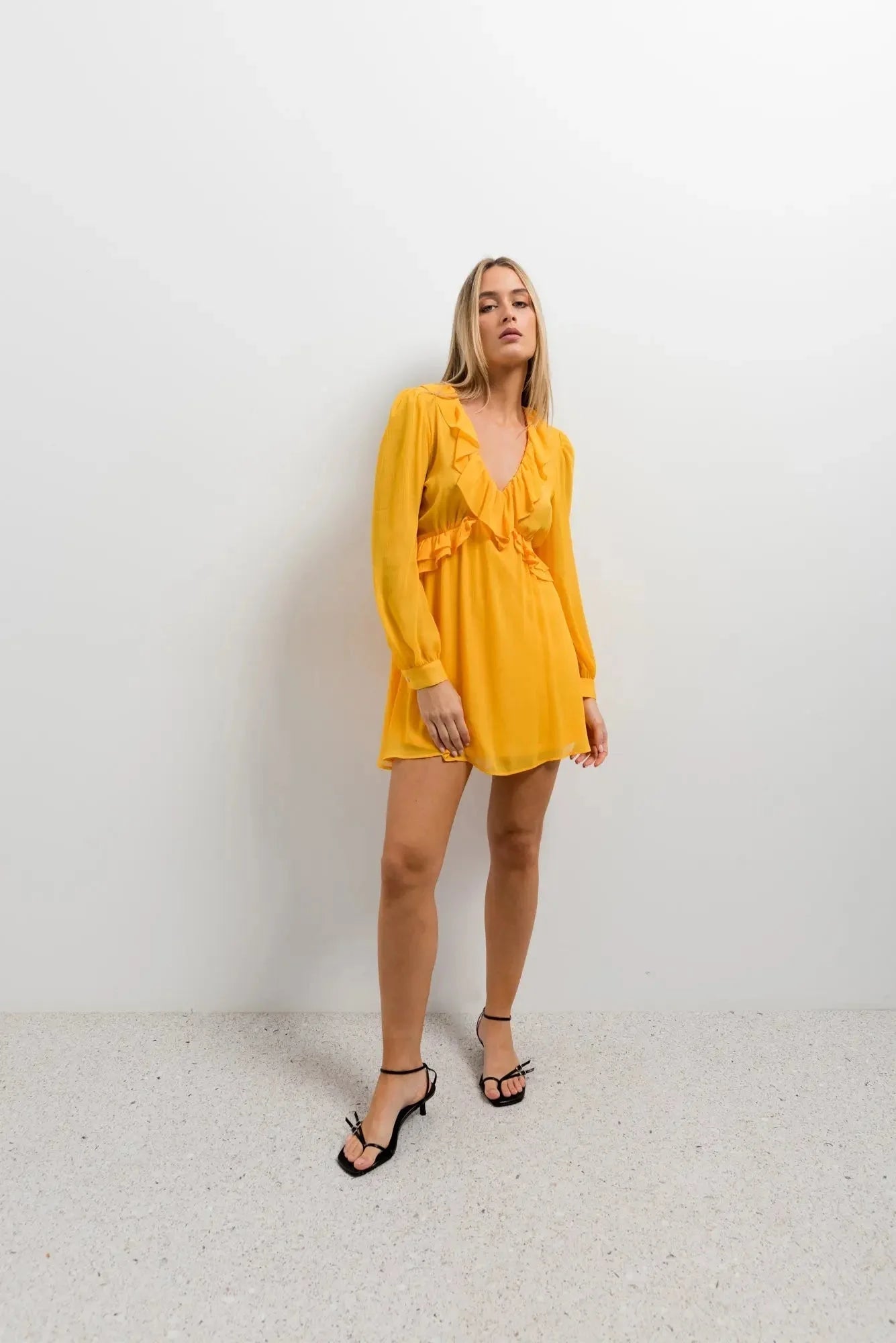 Modèle portant la Mini Robe Courte Jaune à Volants, mettant en avant son élégance et son confort pour chaque occasion, robe courte jaune idéale pour les sorties.