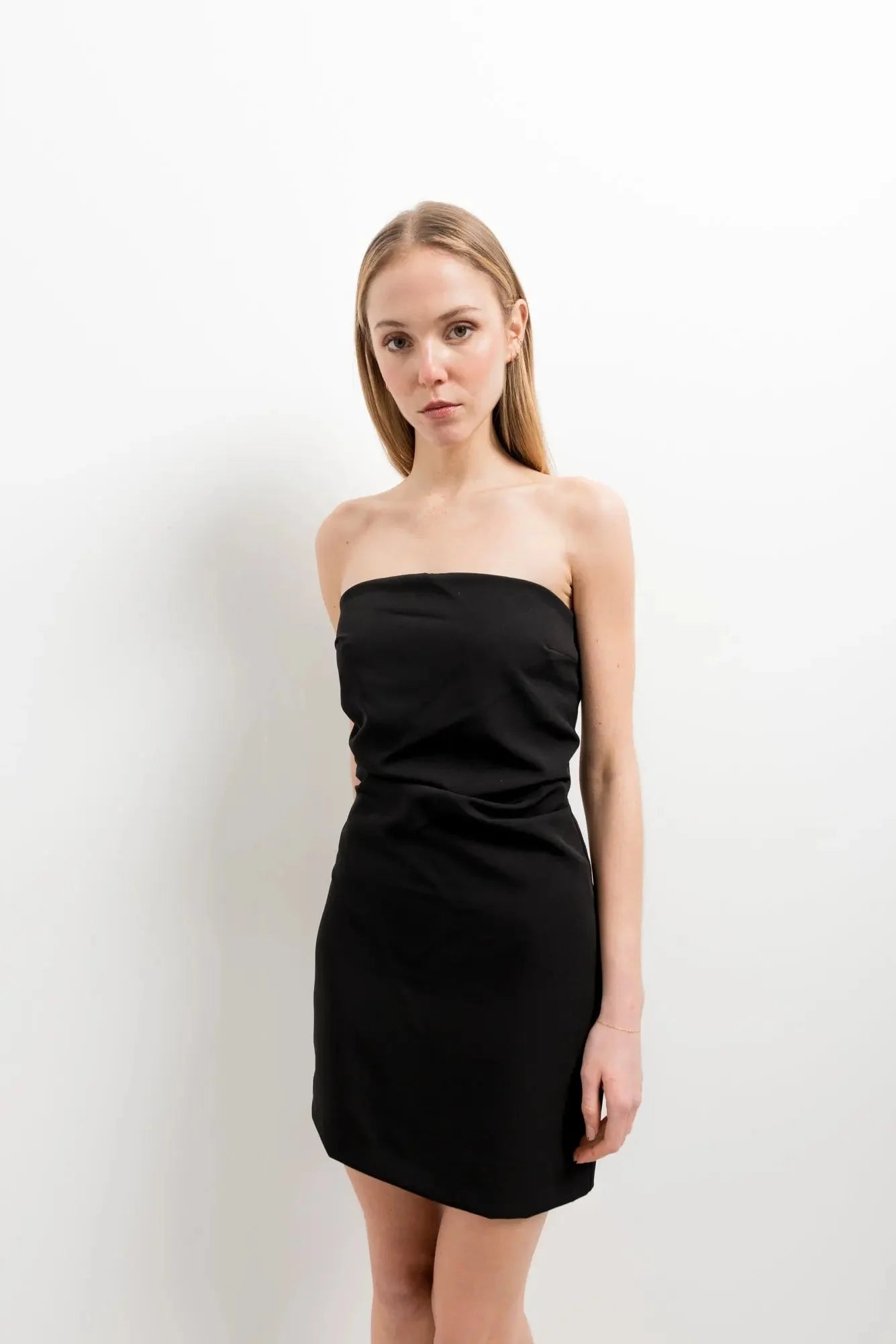 Modèle portant la Mini Robe Noire Drapée Bustier Élégante de Sapiato, offrant confort et style, idéale pour toutes les occasions.
