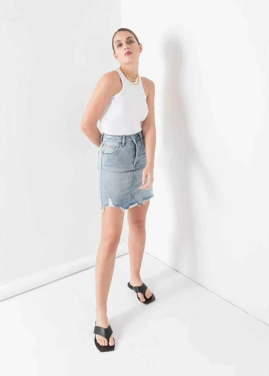 Modèle portant une mini jupe en jean délavé, élégante et facile à entretenir, parfaite pour toutes les occasions.