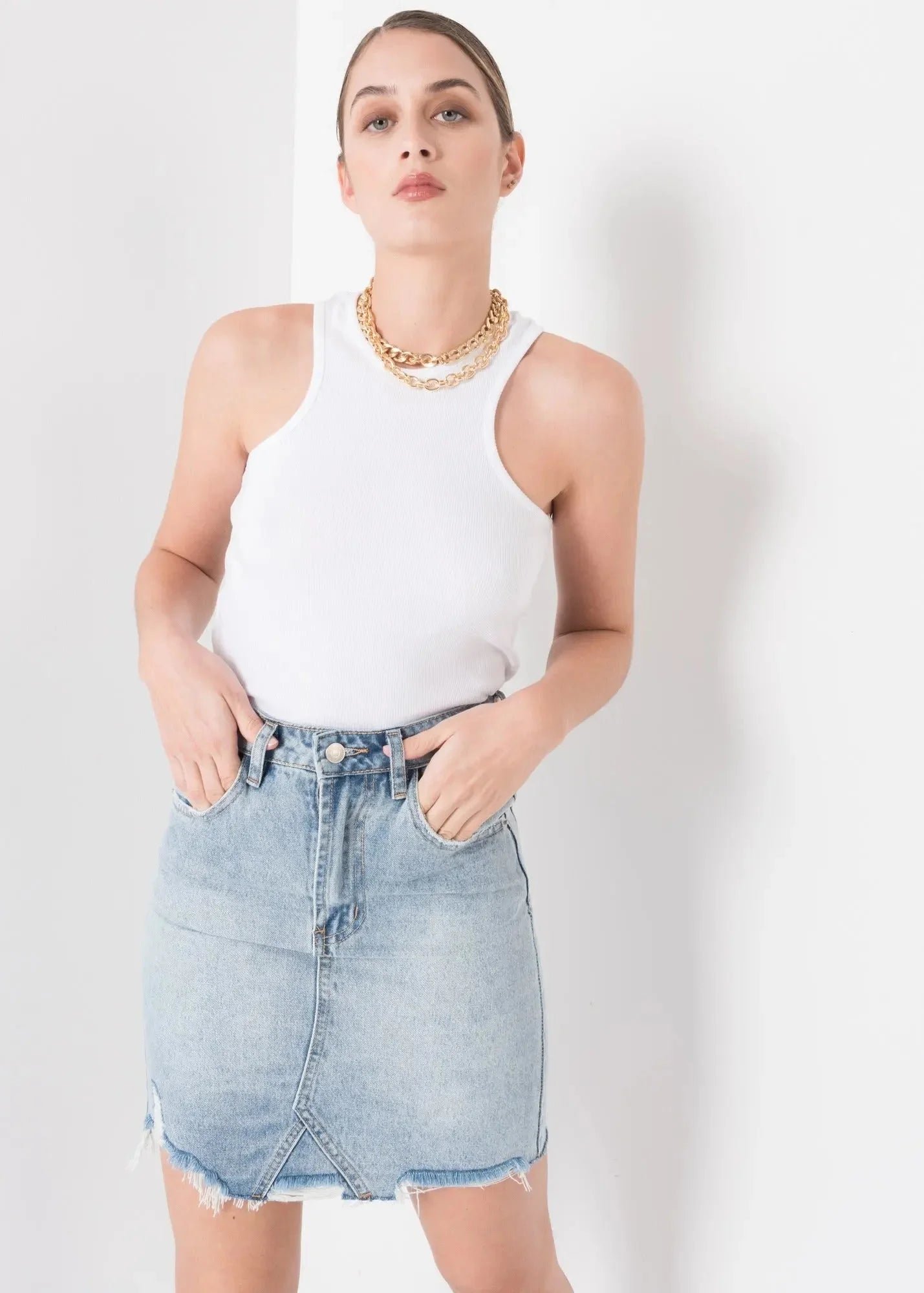 Femme portant une jupe en denim facile à entretenir et un débardeur blanc ribé