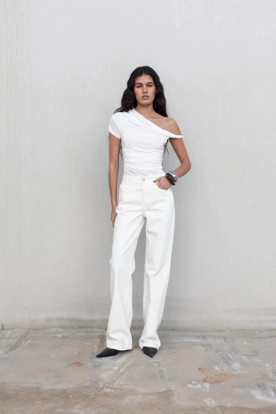 Modèle portant un pantalon blanc femme à jambe large, style urbain, avec un top blanc décontracté.