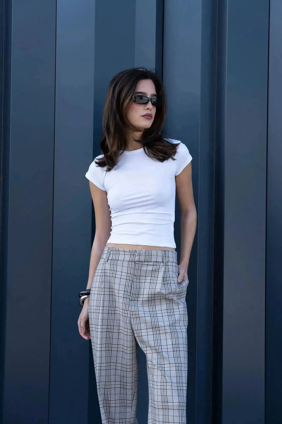 Modèle portant un tee shirt blanc femme fluide en polyamide, avec un style élégant et confortable, associé à un pantalon à carreaux.