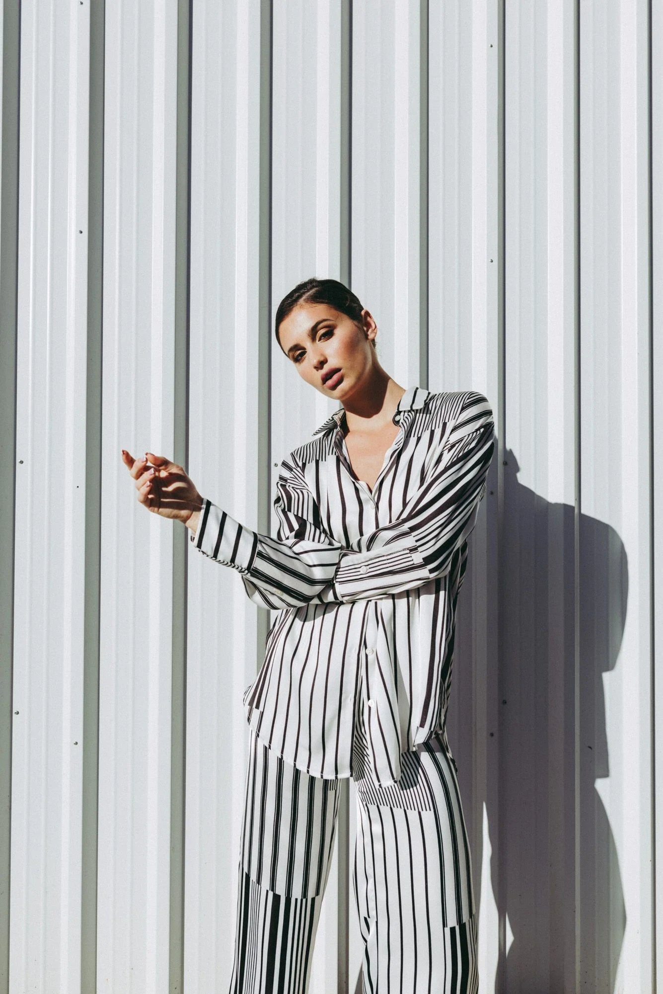 Femme portant un ensemble chemise rayée et pantalon coupe fluide noir blanc