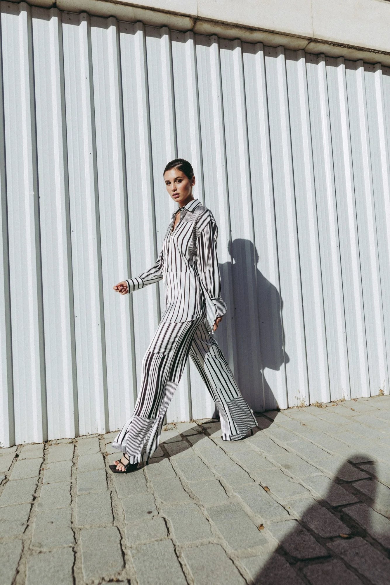 Femme portant une chemise rayée et un pantalon coupe fluide noir blanc