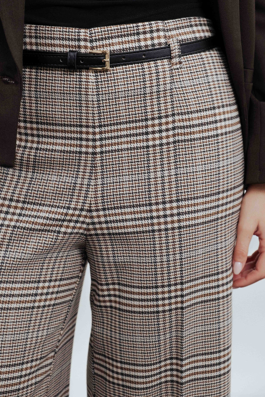 Détail de la ceinture noire à boucle métallique du pantalon culotte à carreaux