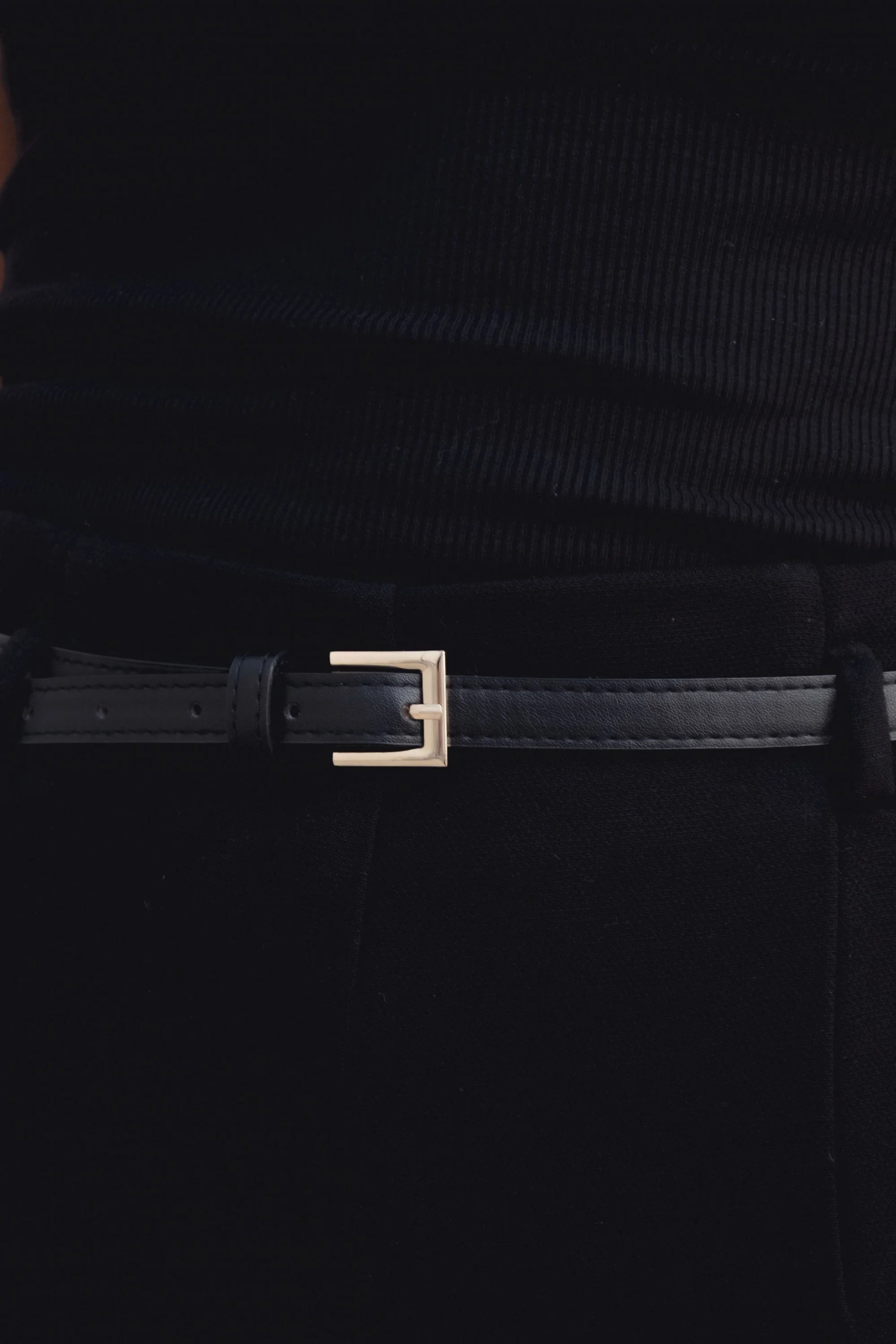 Zoom sur la ceinture d'un pantalon culotte taille haute jambe large noir boucle métallique, mettant en avant son design élégant et chic.