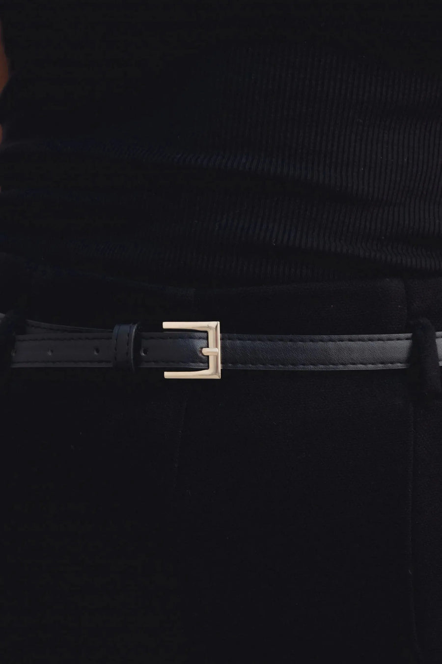 Zoom sur la ceinture d'un pantalon culotte taille haute jambe large noir boucle métallique, mettant en avant son design élégant et chic.