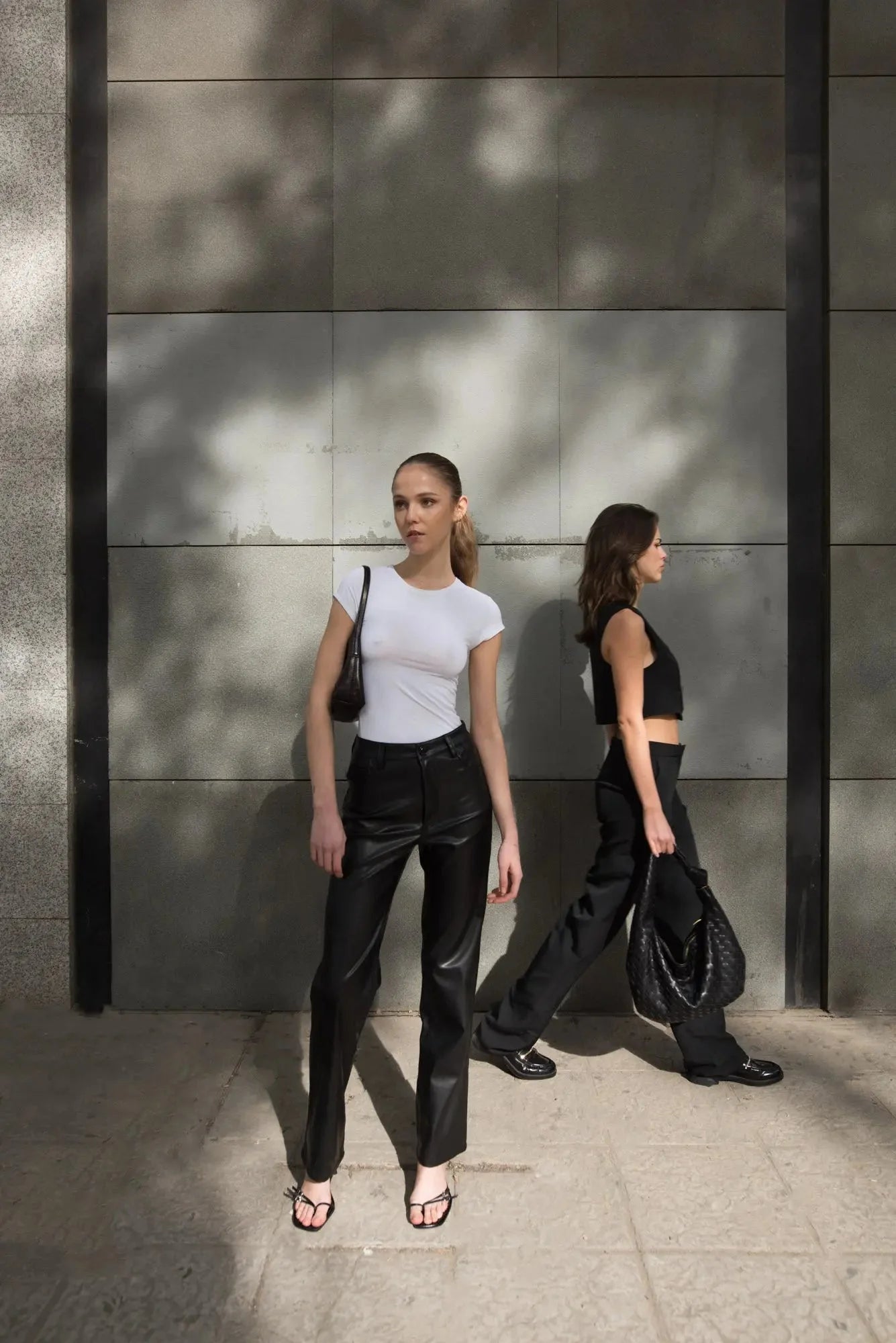 Deux jeunes femmes portant le pantalon effet cuir noir élégant et tendance