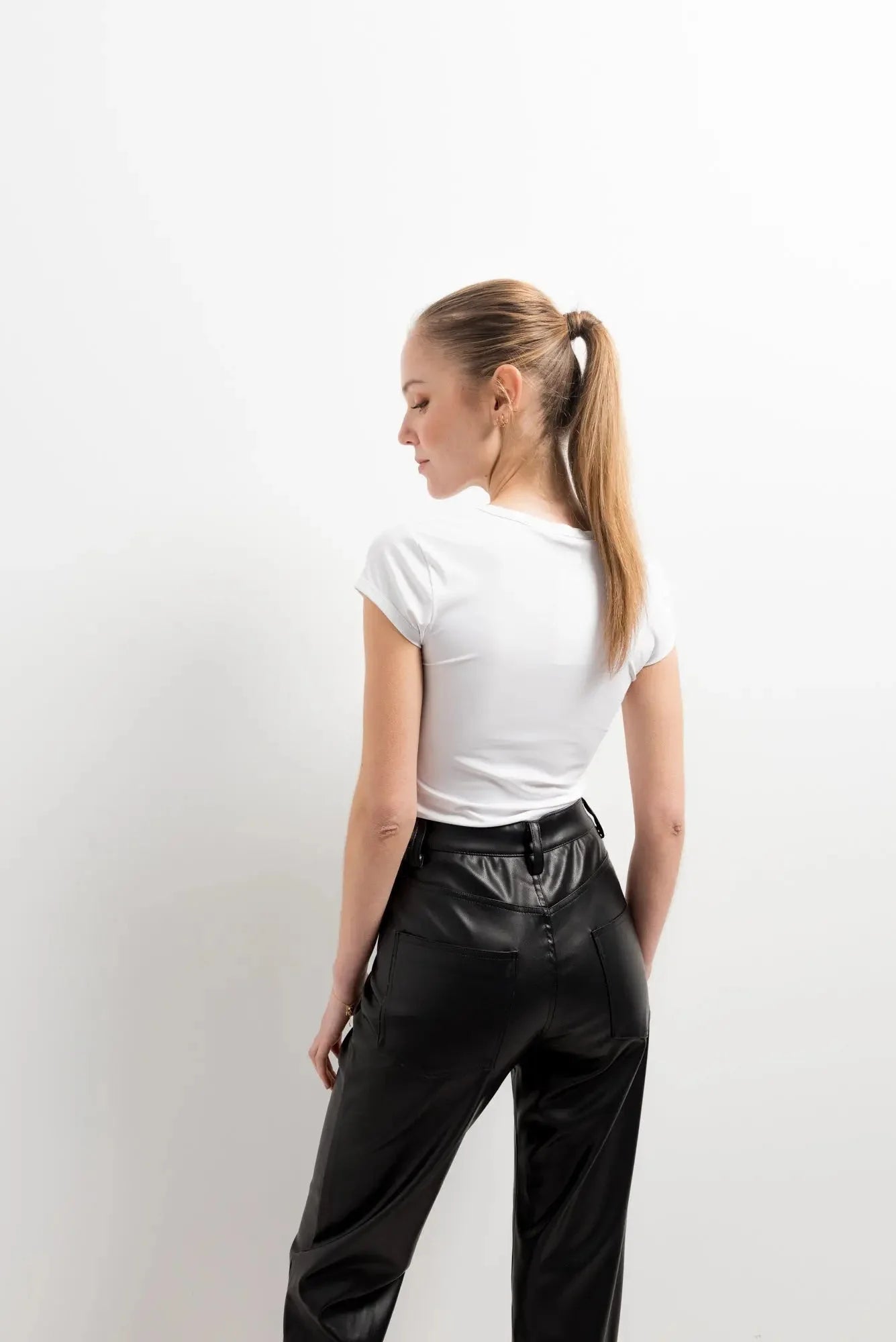 Femme portant un pantalon effet cuir noir élégant et un t-shirt blanc, Pantalon Effet Cuir
